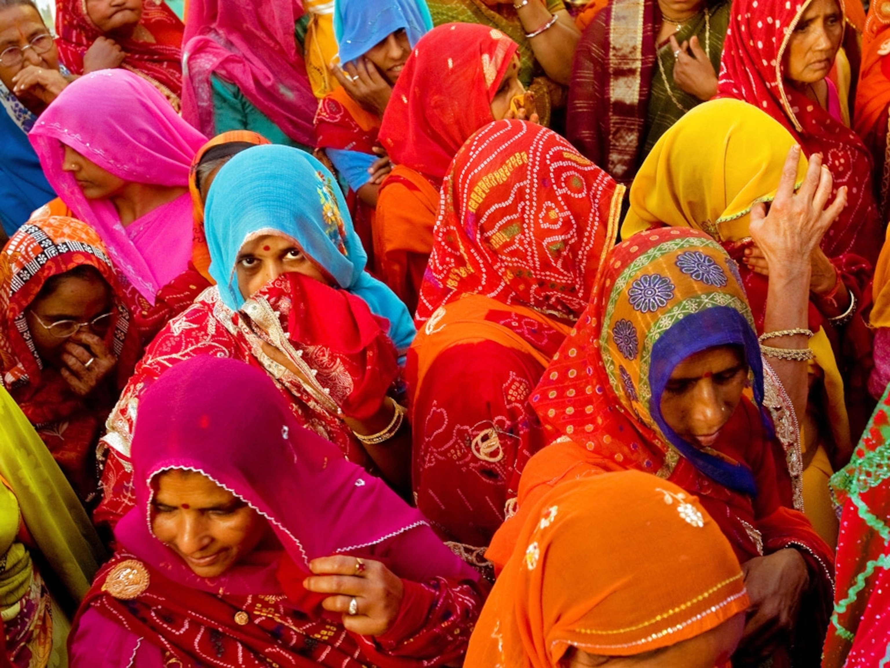 Brightly attired Indian women clustered together
