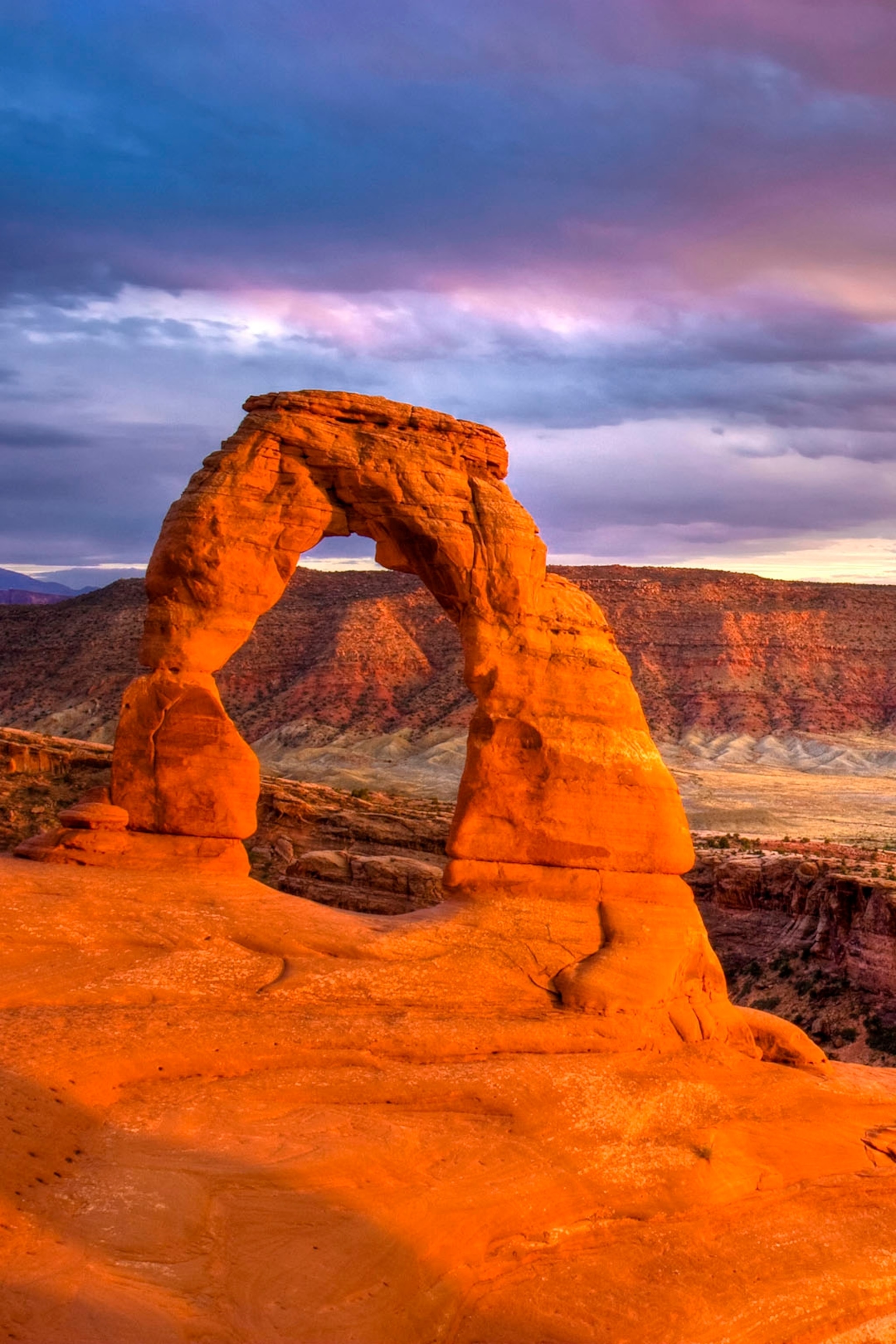 A sunset-lit rock arch in a national park.