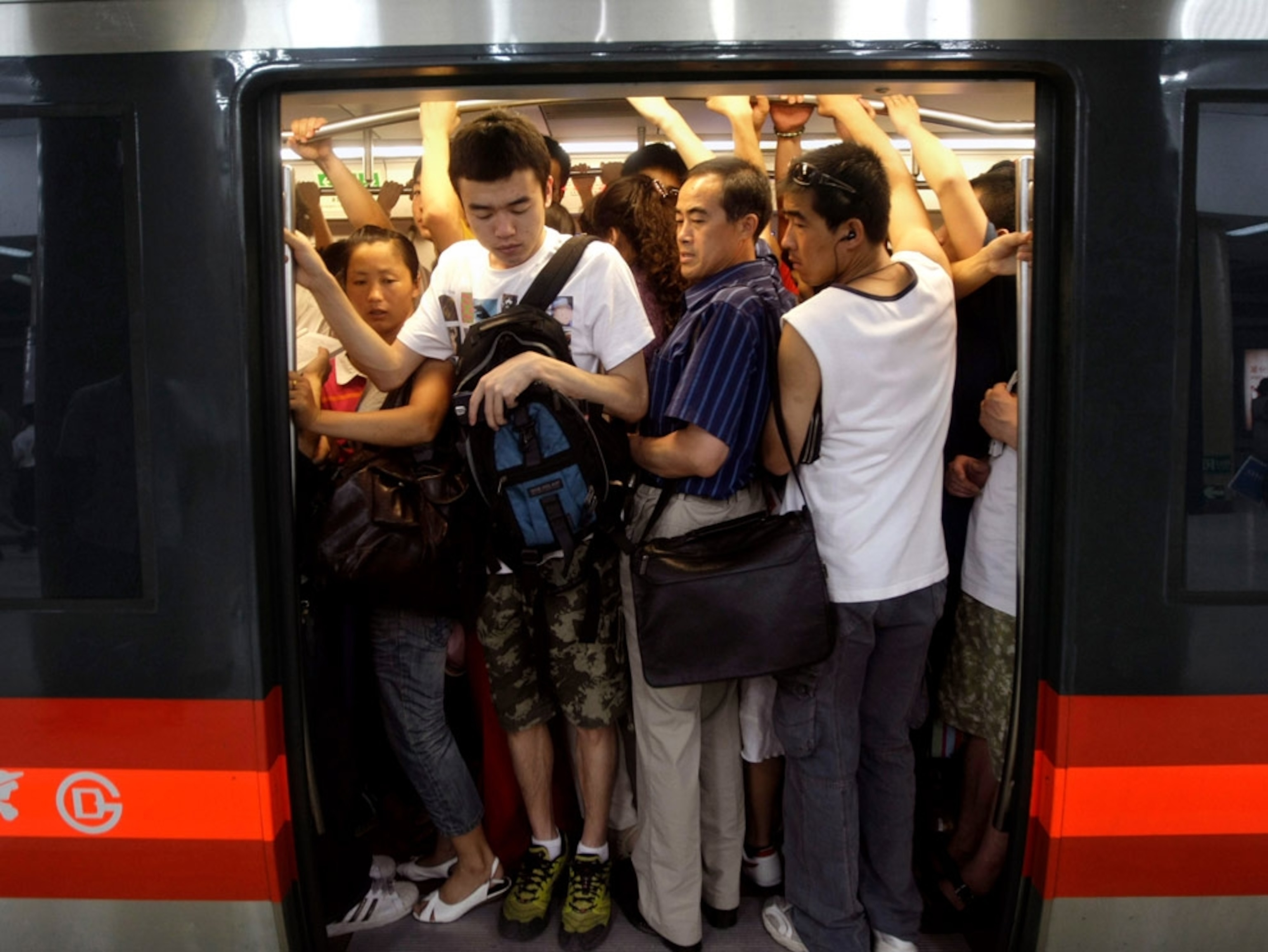 Passengers cramming onto a loaded subway train