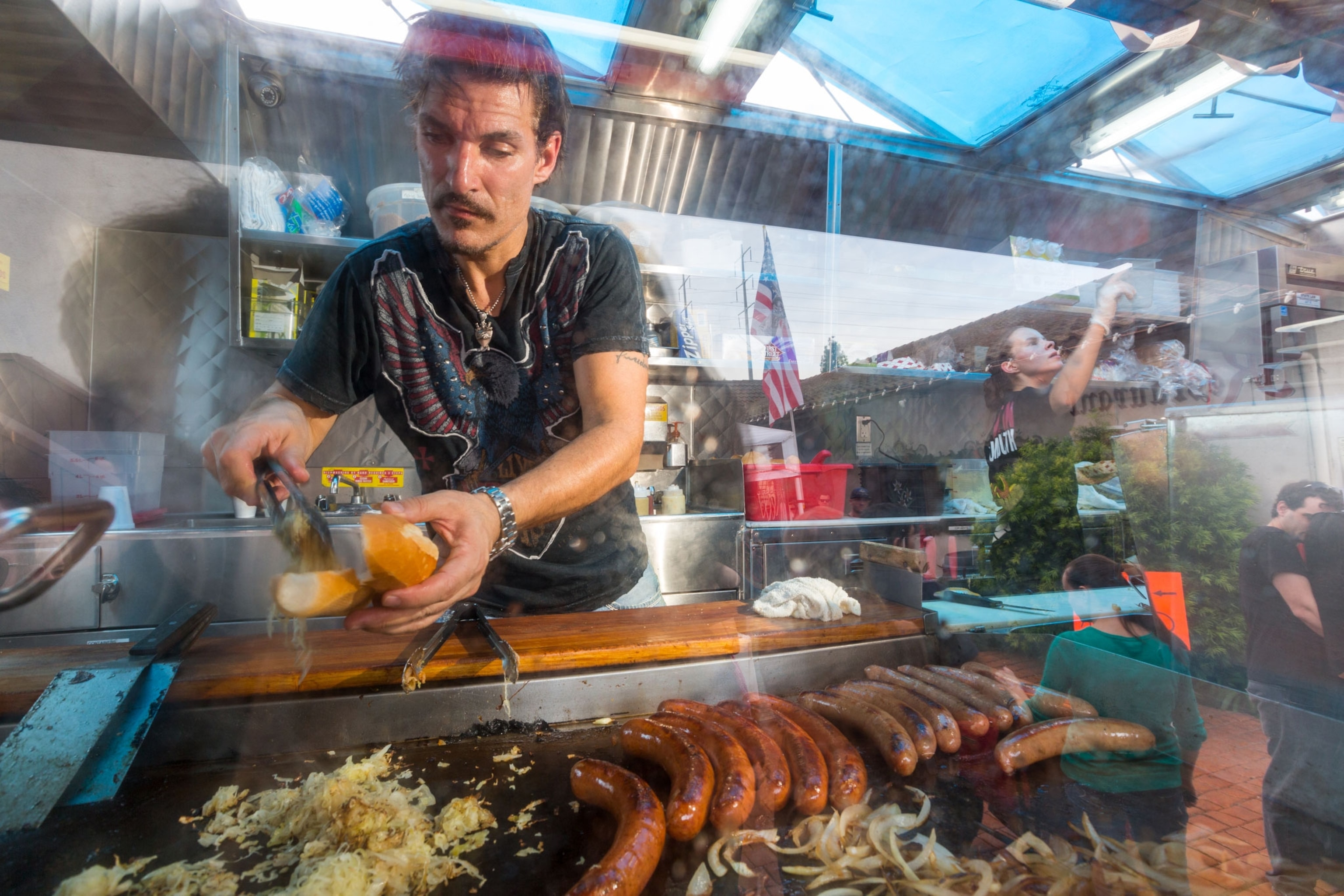 A man cooks at the Currywust truck in LA
