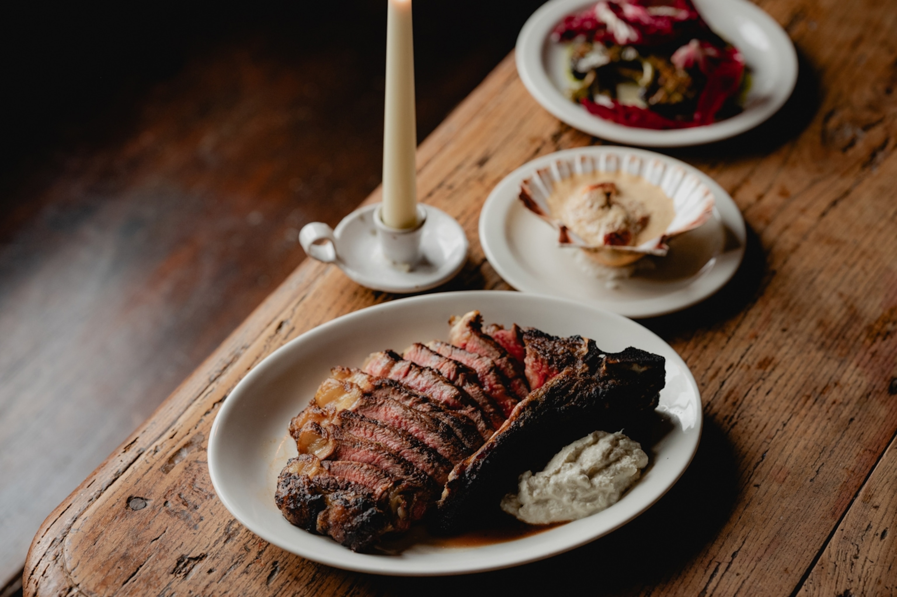plates of food on a wooden table with candle