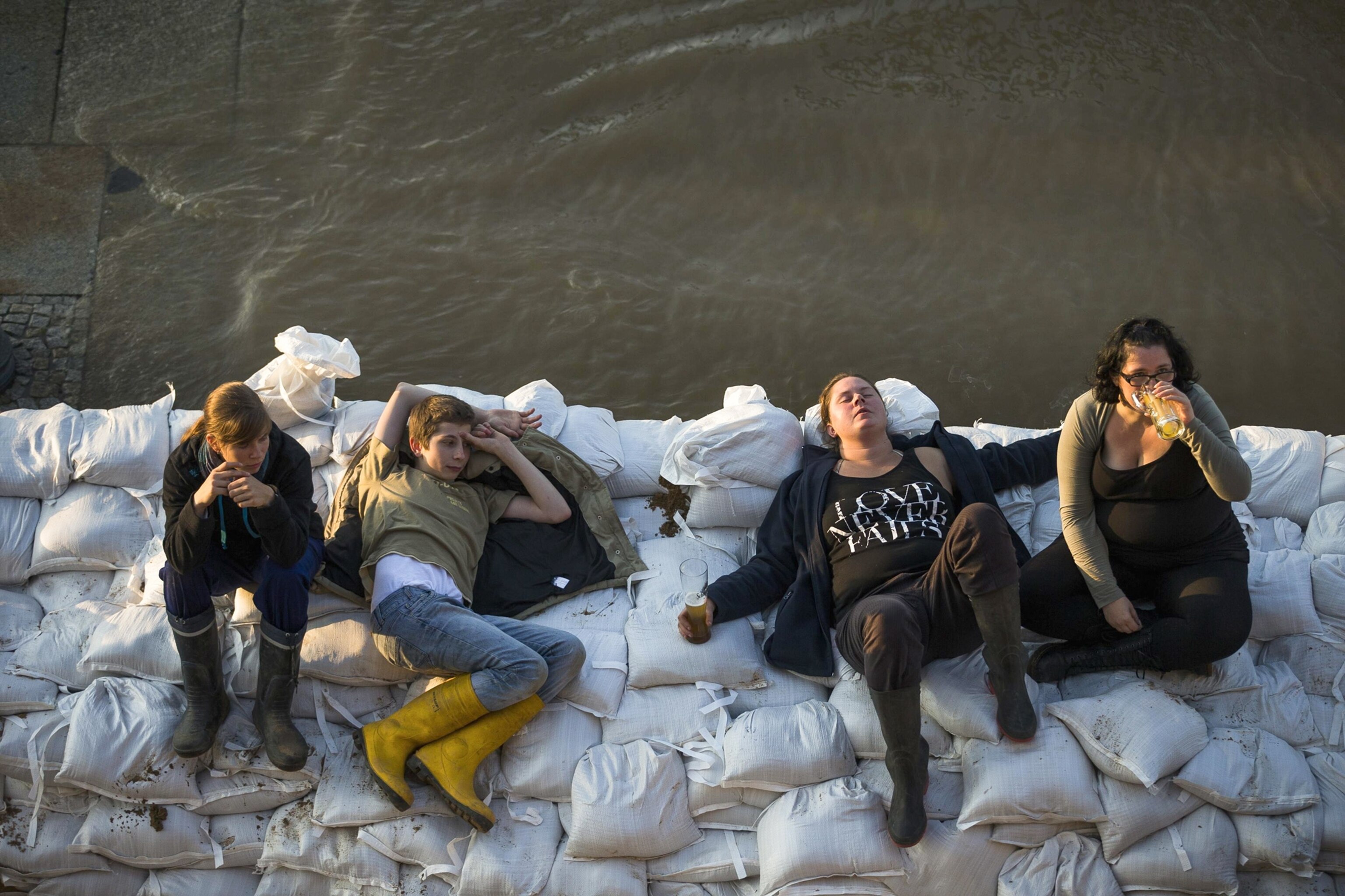 European Flooding - Picture of people sitting on sandbags during flood