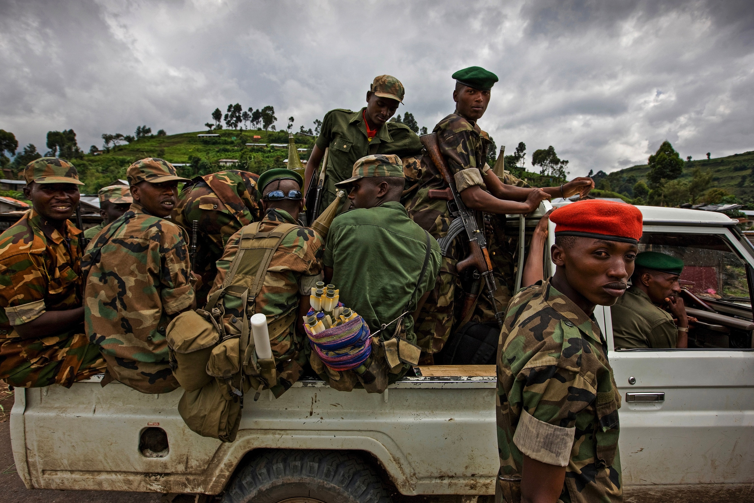 A truck full of people wearing military uniforms with weapons