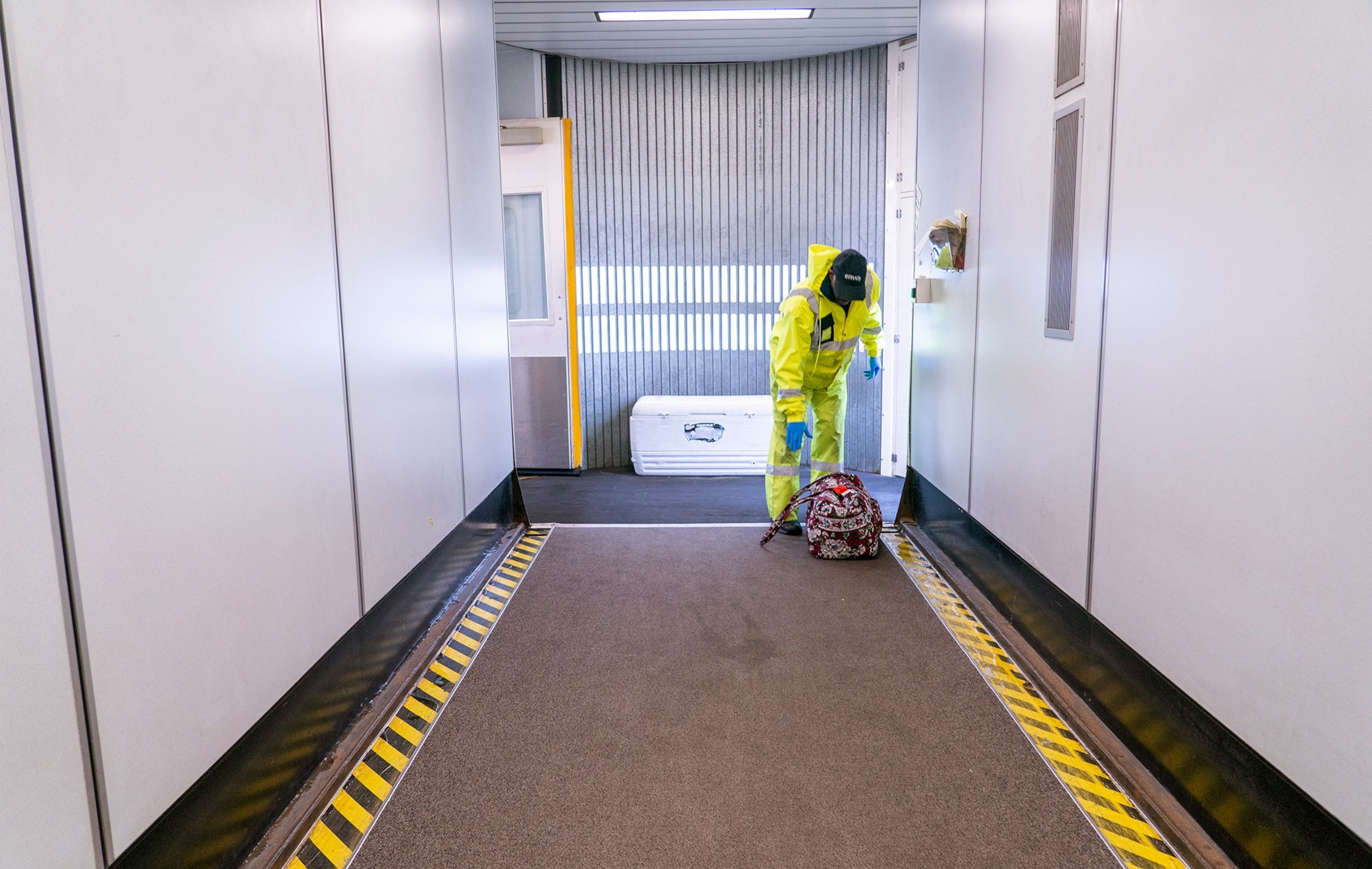 an employee picking up a single bag in the jet bridge at the Dayton International Airport