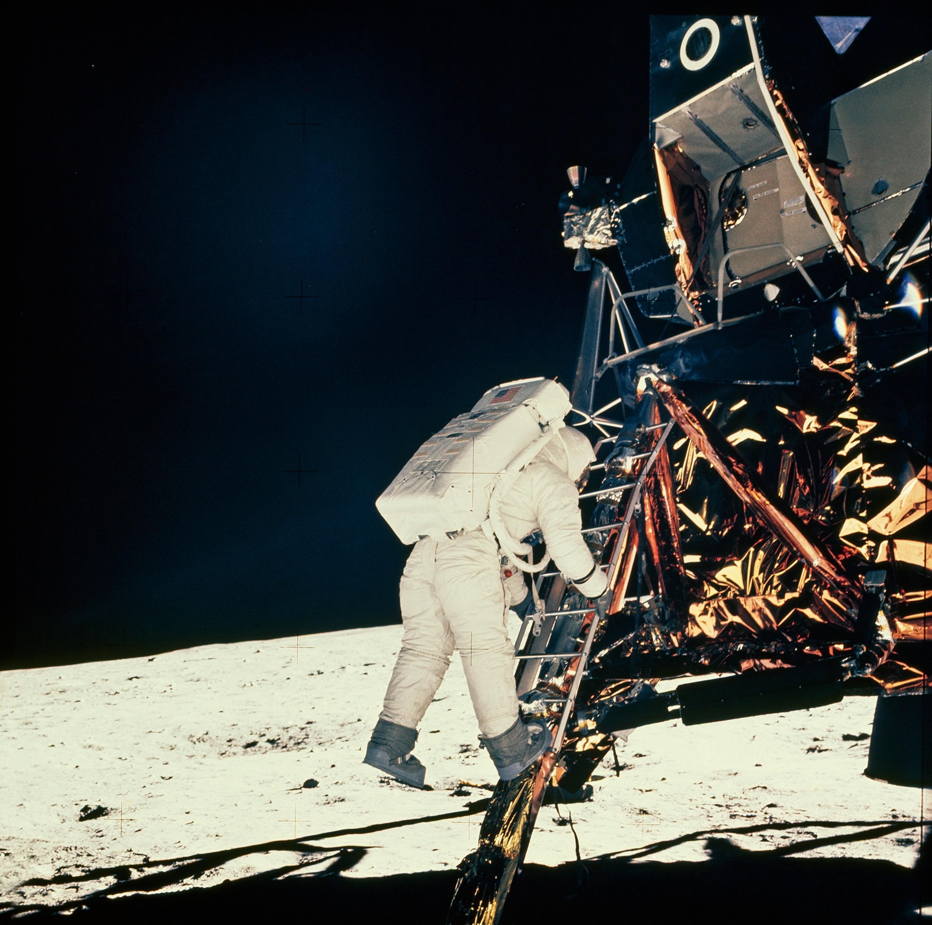 An eager Aldrin joins Armstrong on the moon 19 minutes later. On his back rides a portable life-support system with oxygen for breathing, water for cooling, and electric-power supply, and radio equipment.