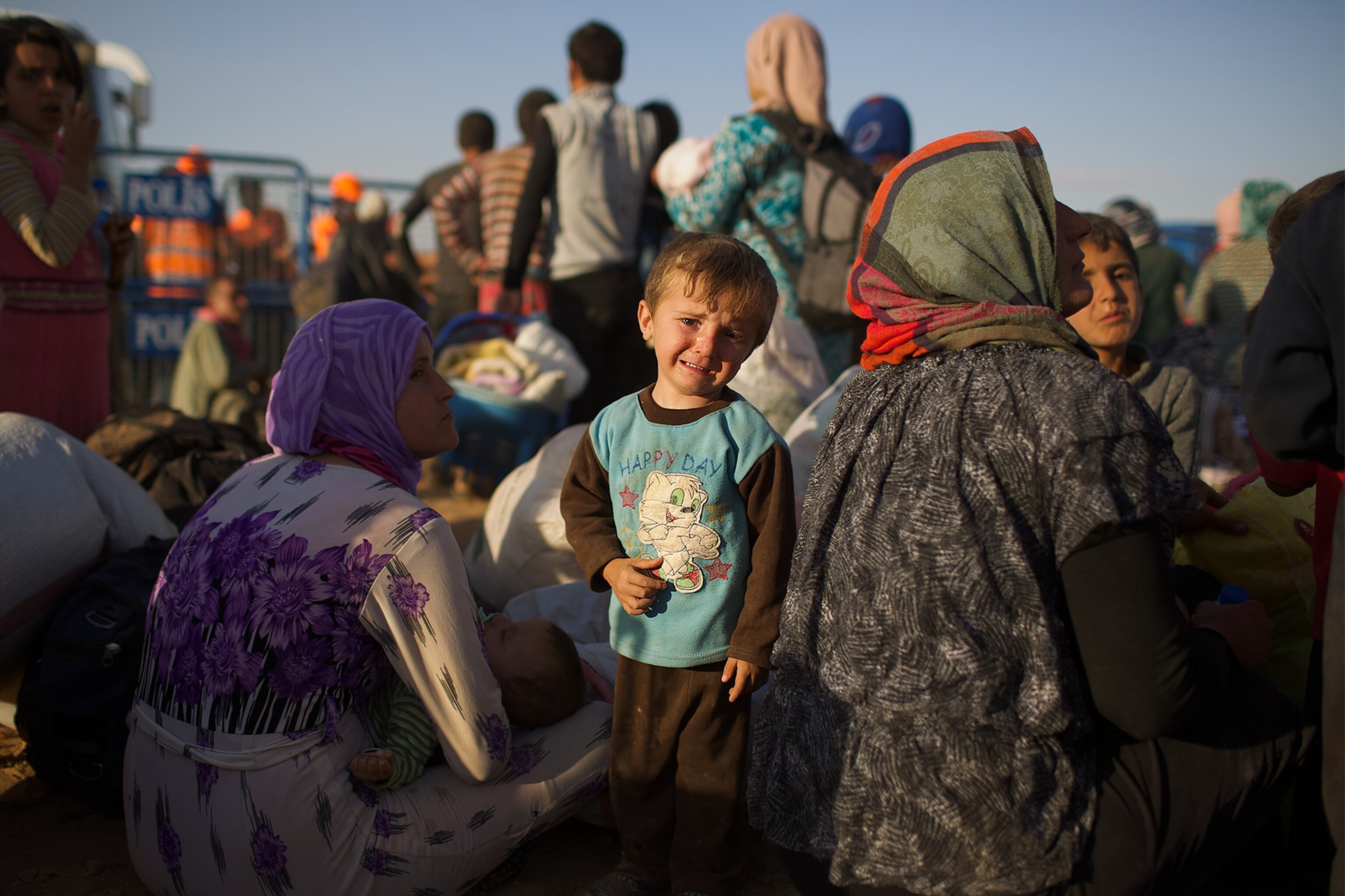 a Syrian women carrying a baby after fleeing to Turkey with thousands of others.