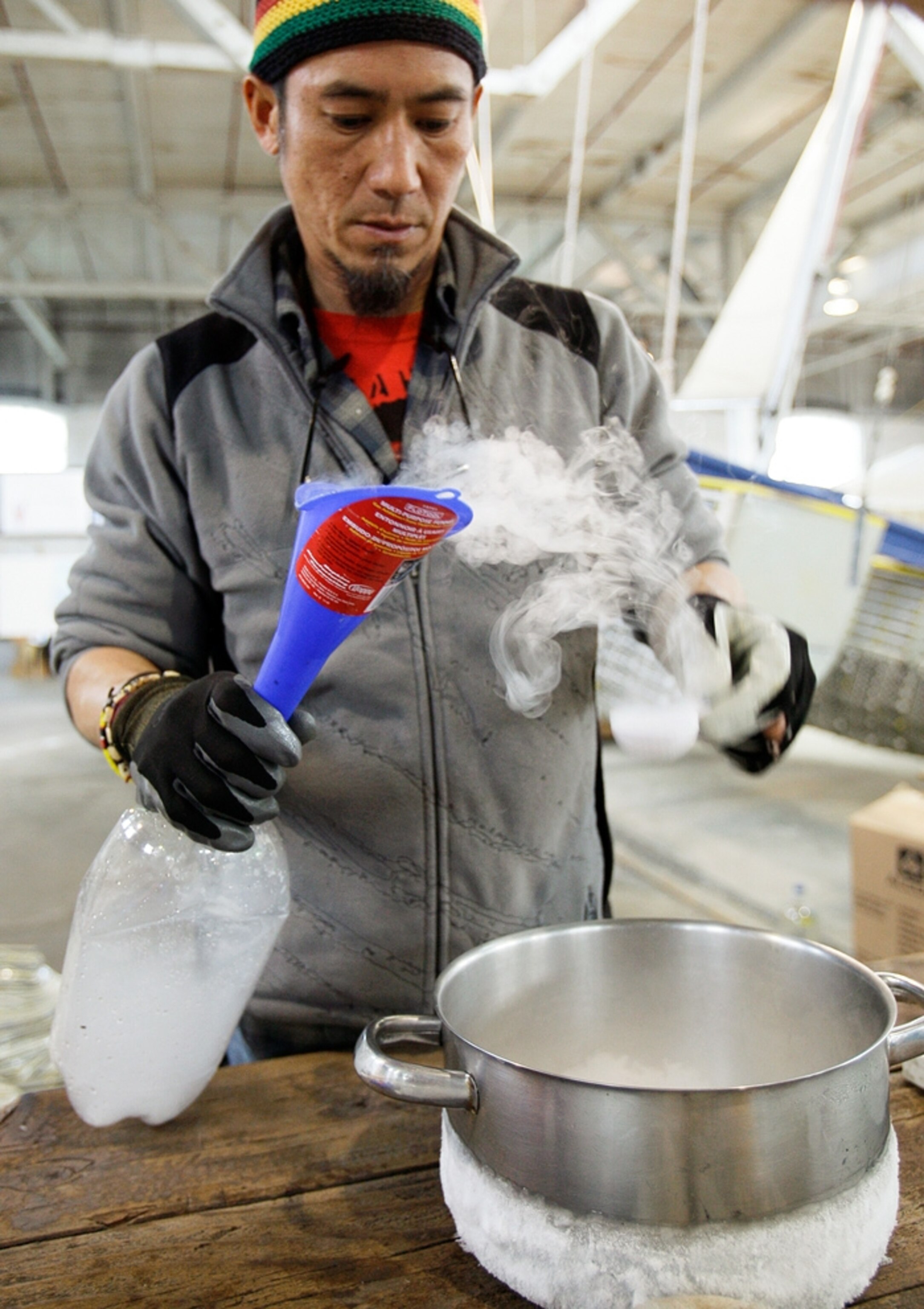 A man drops dry ice into an empty plastic drink bottle