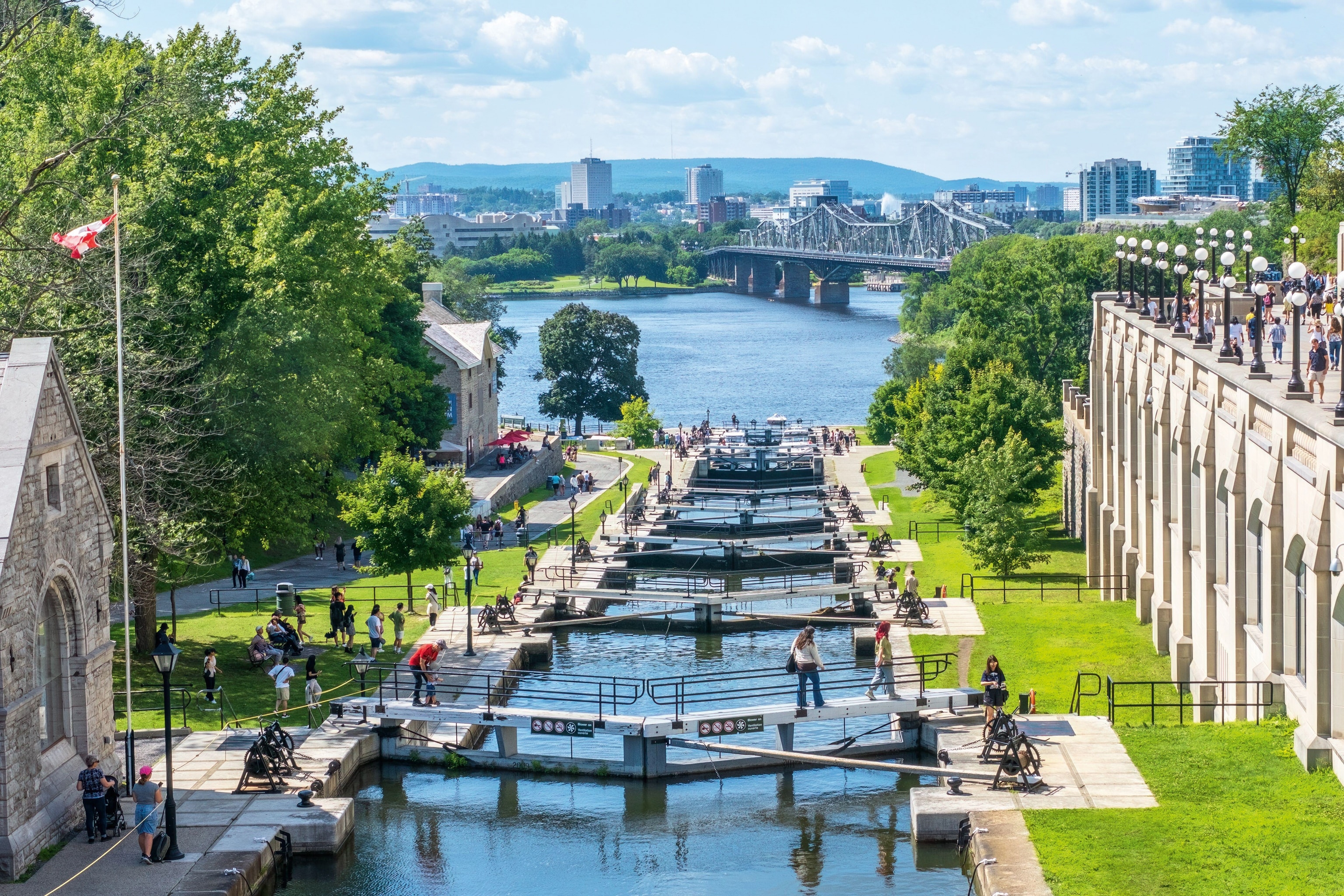 Canal with multiple walkways across, leading out to a larger river