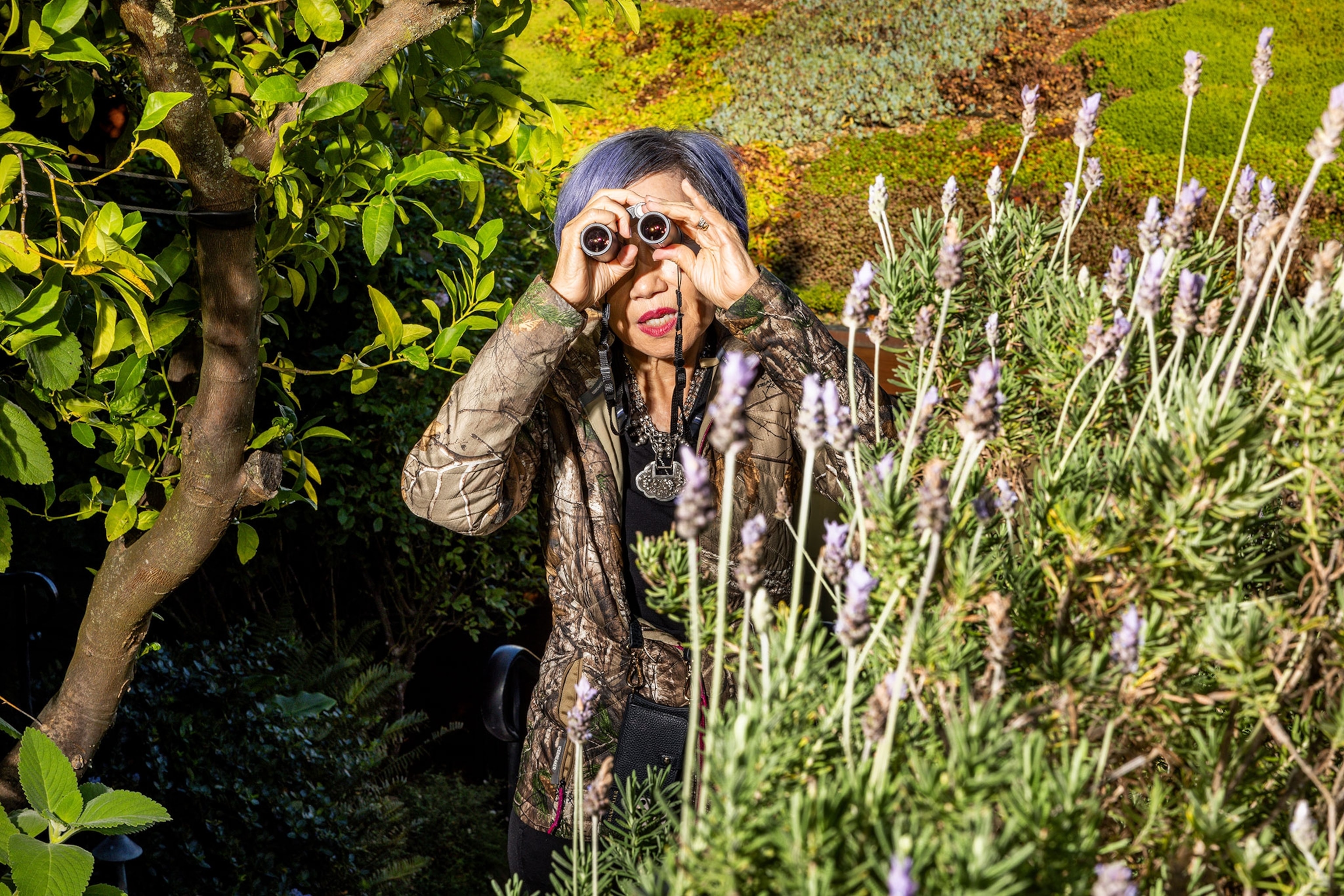 A woman with binoculars looks out into the distance
