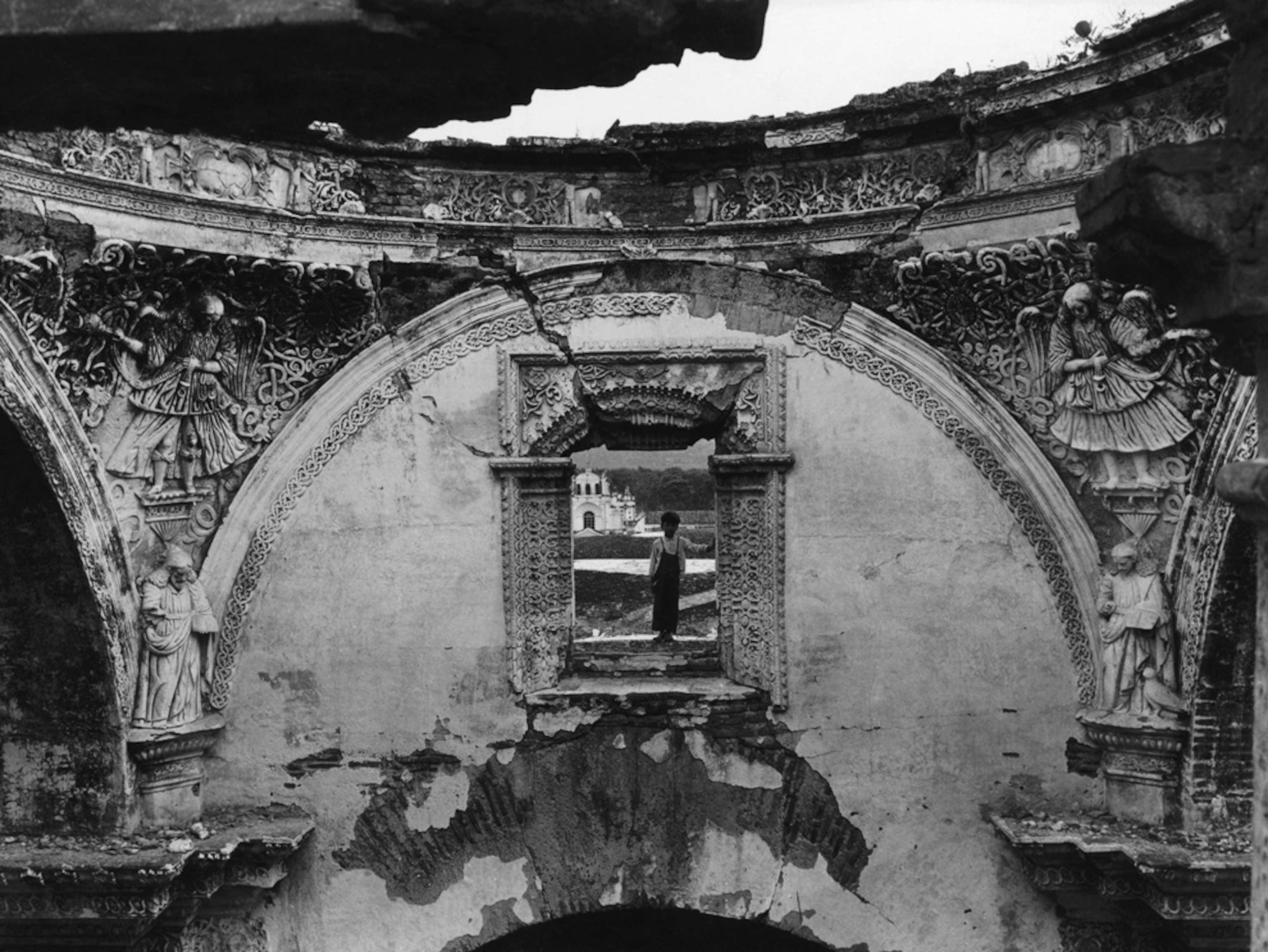 Child seen through the window of a ruined cathedral