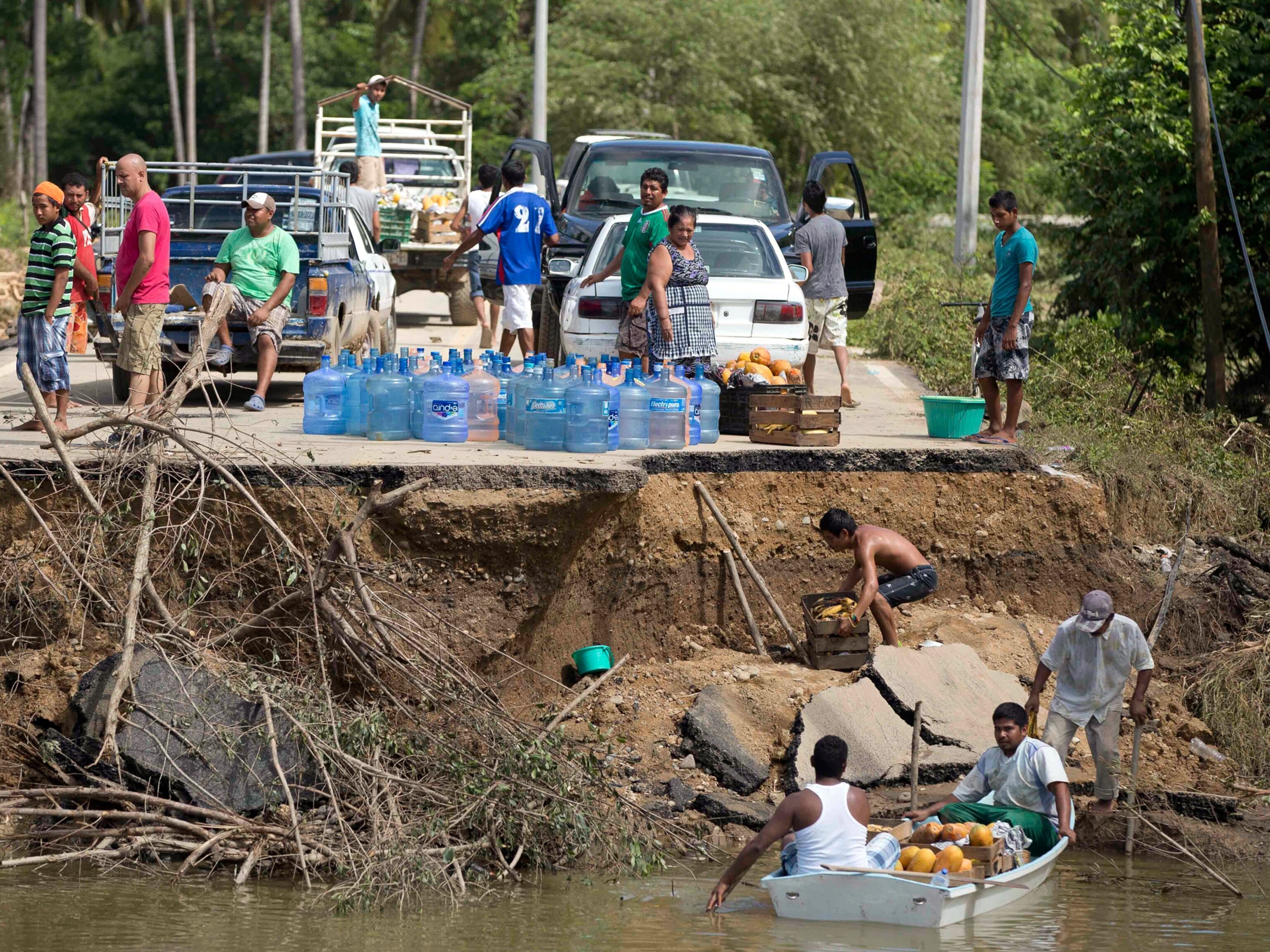 people waiting for a boat to ferry them across a river after the bridge collapsed