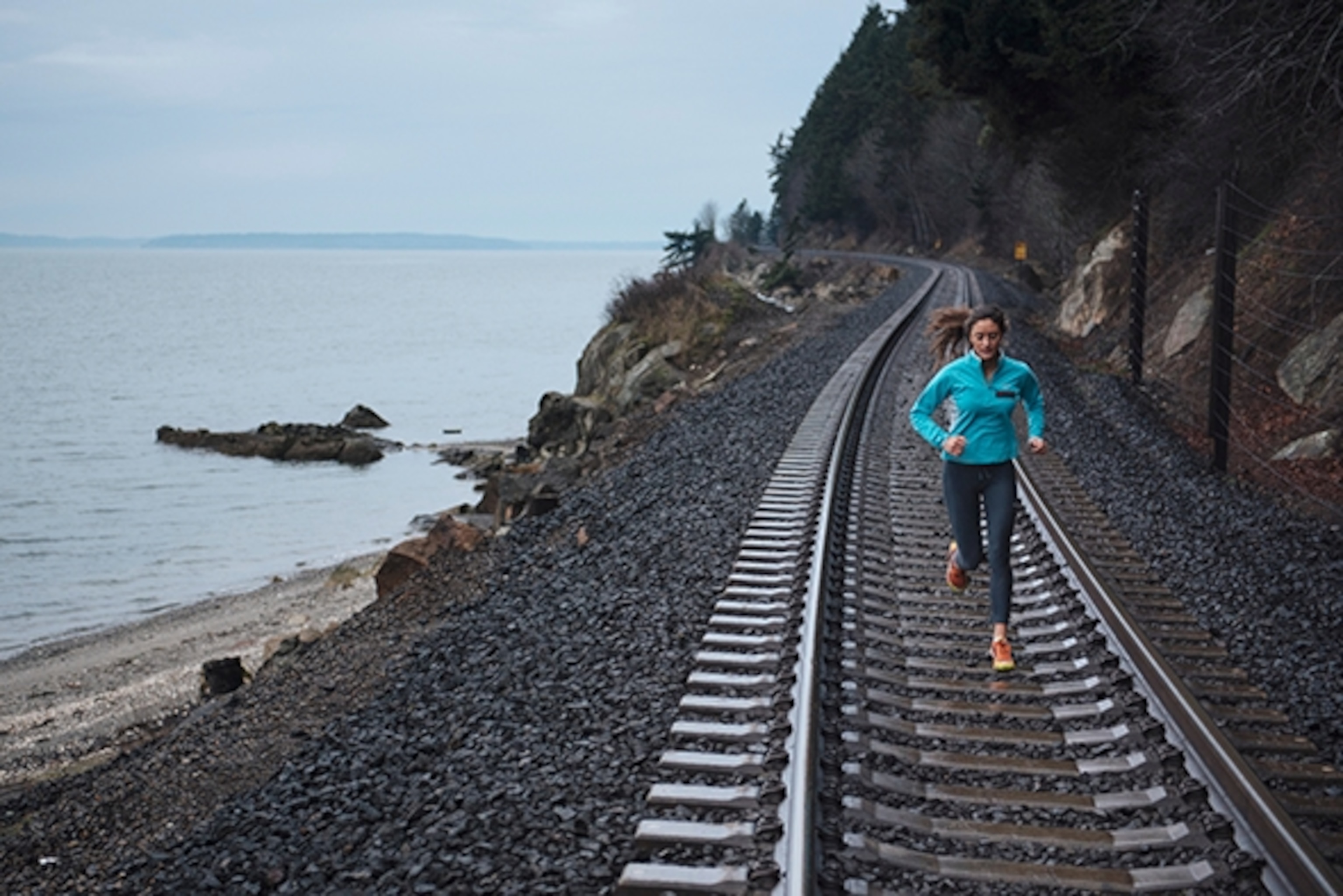 Christina Volken running the coastal train tracks on Chuckanut Bay
