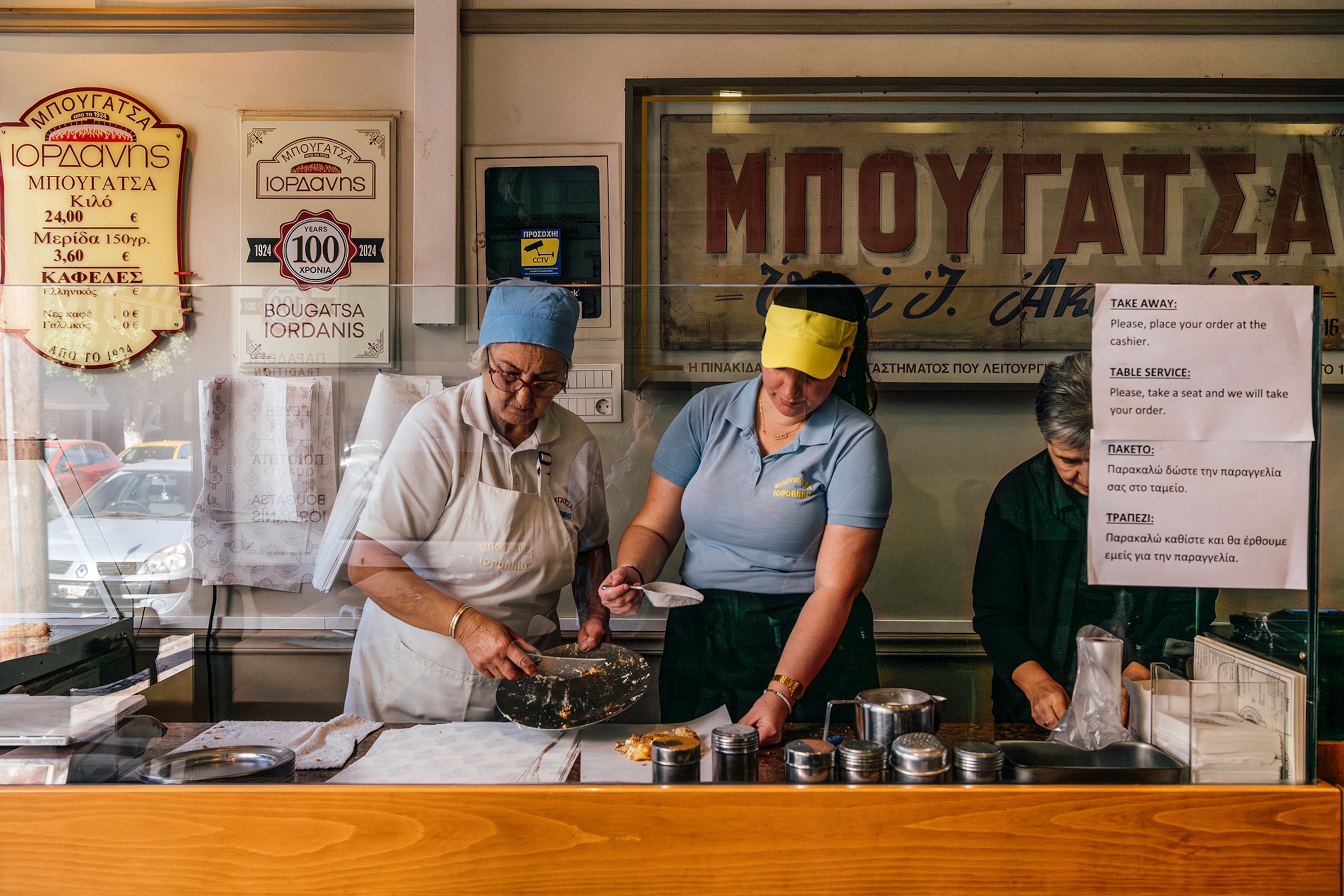 Two women making pies at a bakery.
