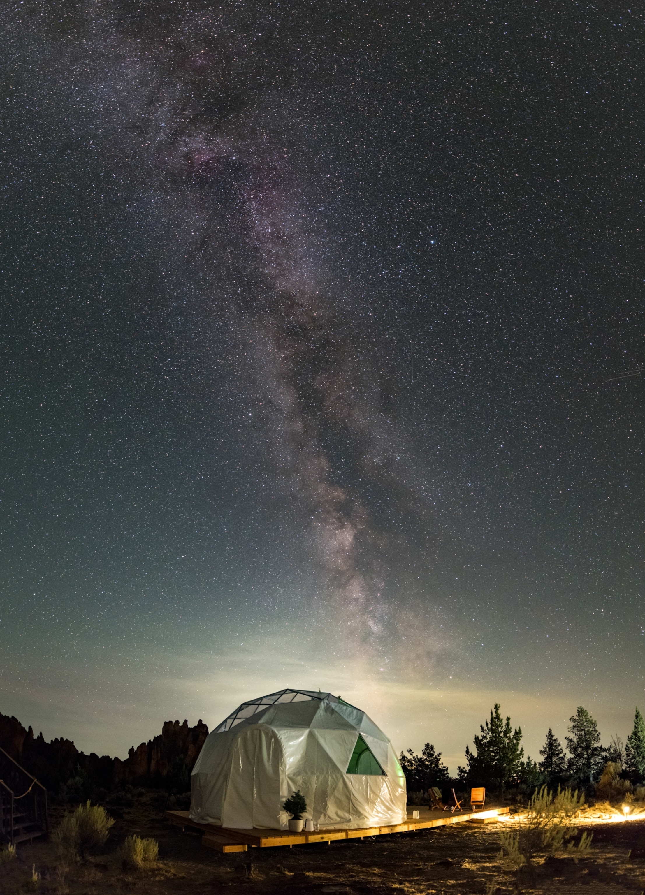 The Milky Way in a starry summer night above a geodesic dome used as a temporary accommodation.