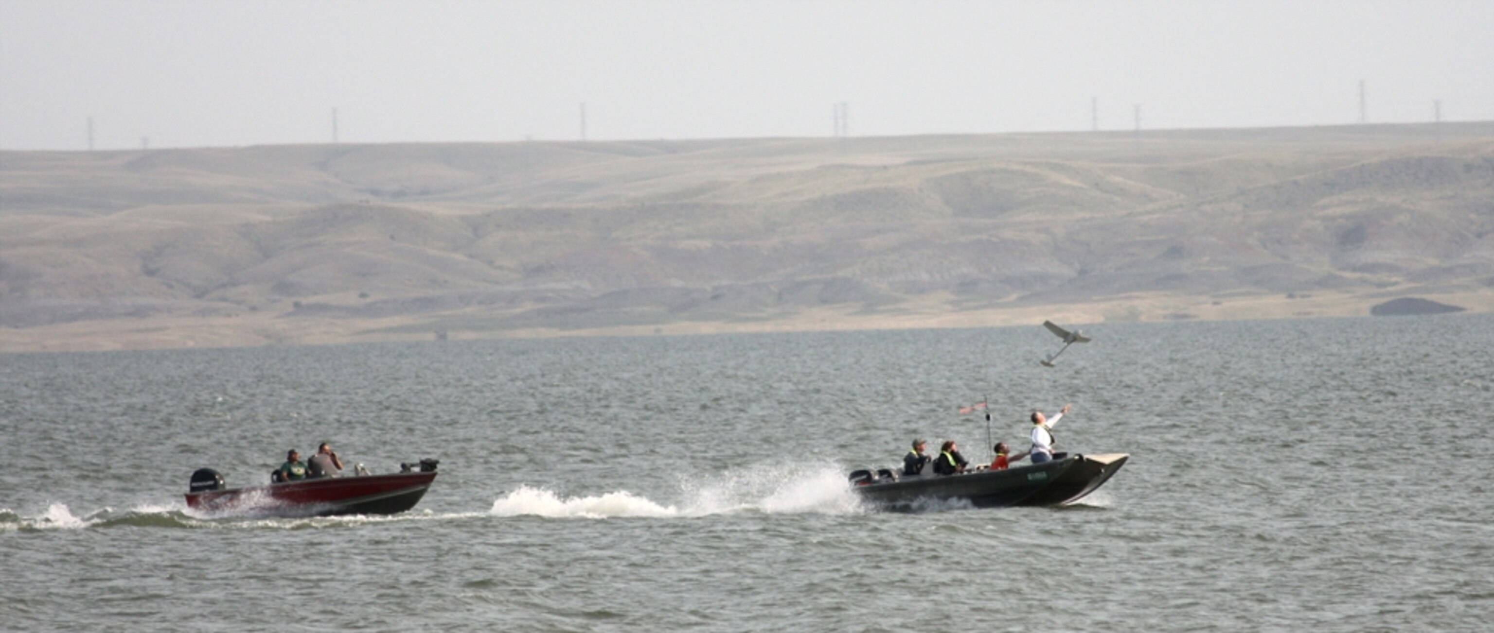 people on a boat launching a drone