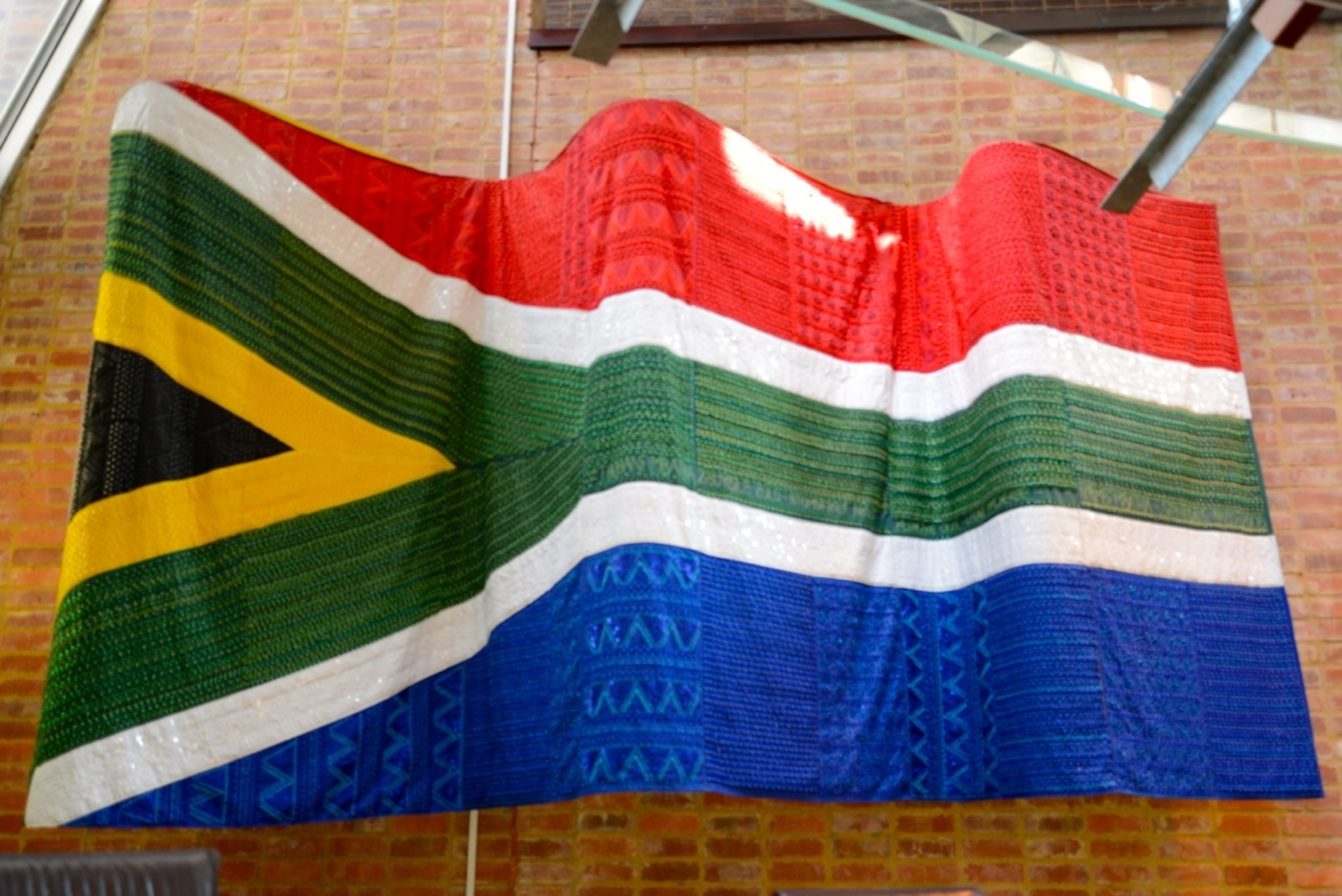 A giant, beaded, South African flag flies over the country's Constitutional Court in Johannesburg, once the sight of the infamous political prison, Number Four. (Photo by Andrew Evans, National Geographic).