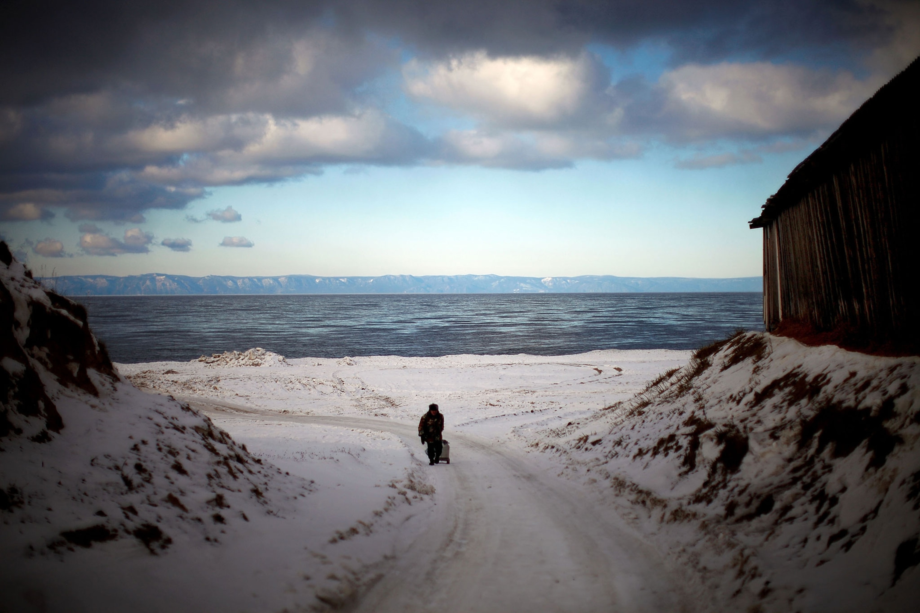 storm clouds pass above a wintery landscape on the shores of Lake Baikal in Russia