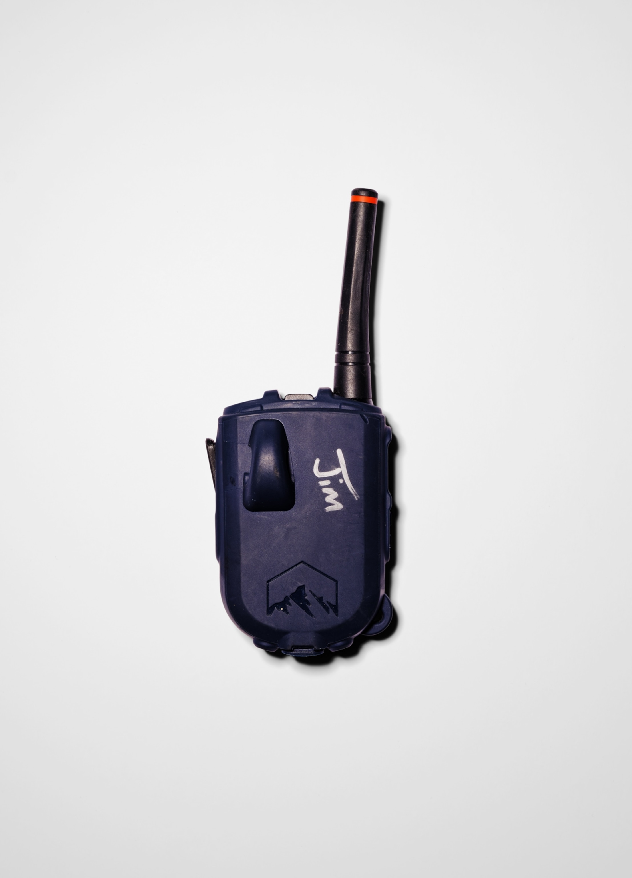 A black walkie talkie radio lies on a white background