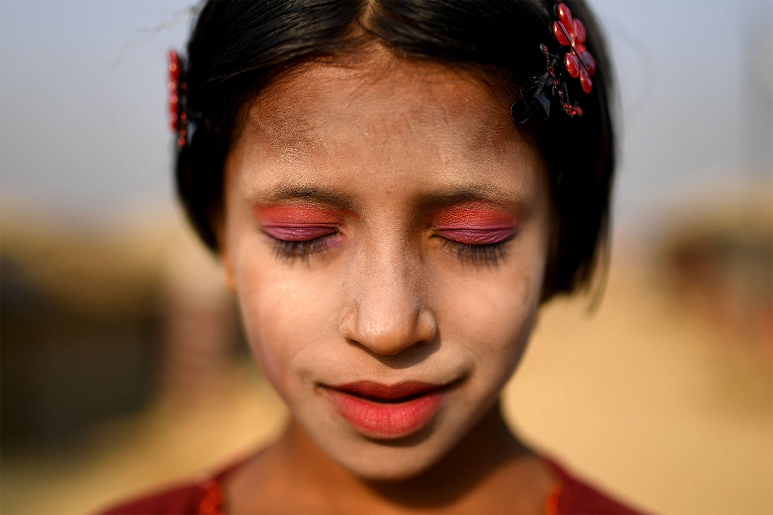 a Rohingya girl wearing paint on her face to protect her from the sun