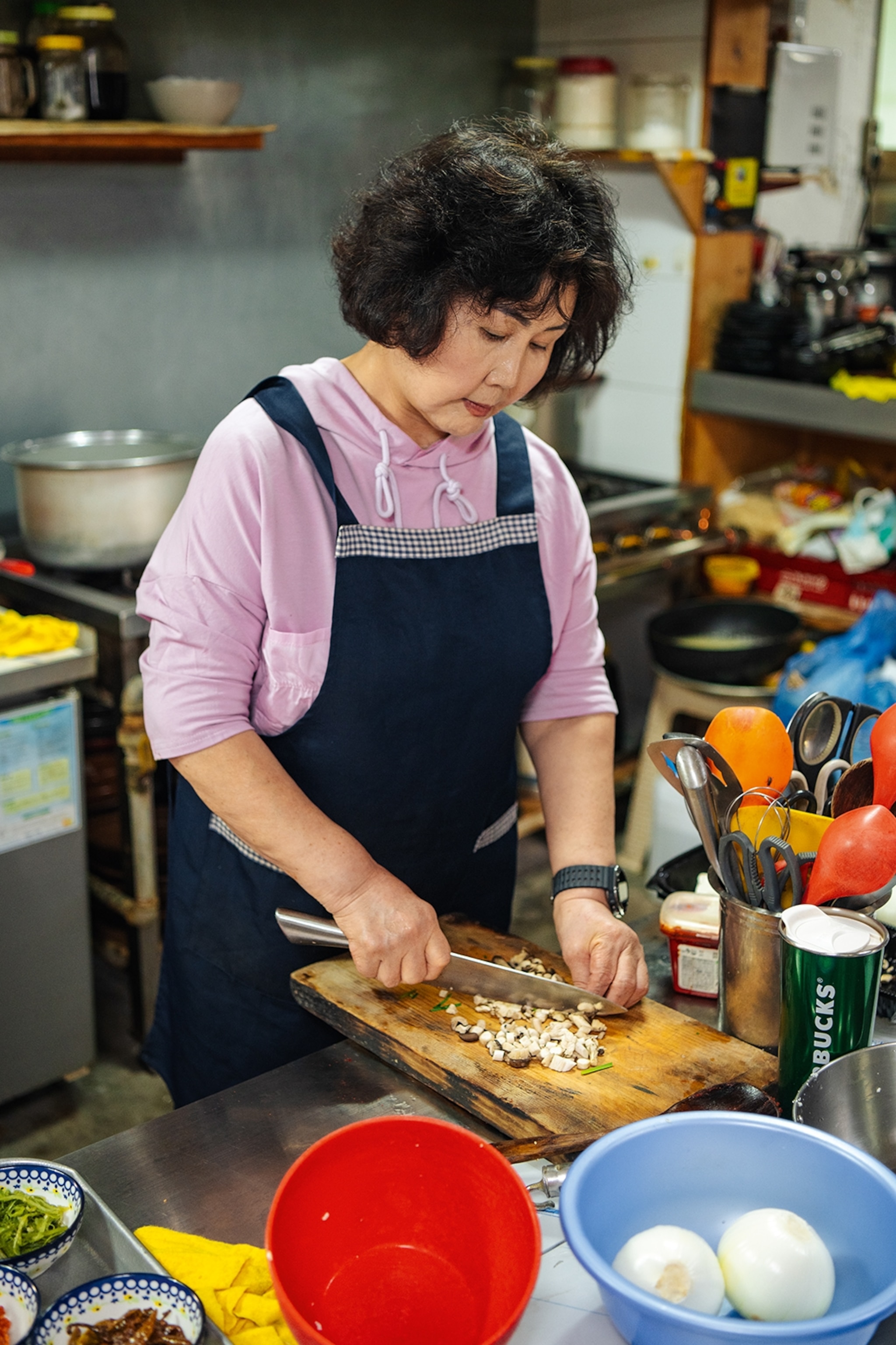 Restaurant owner prepares food in kitchen.