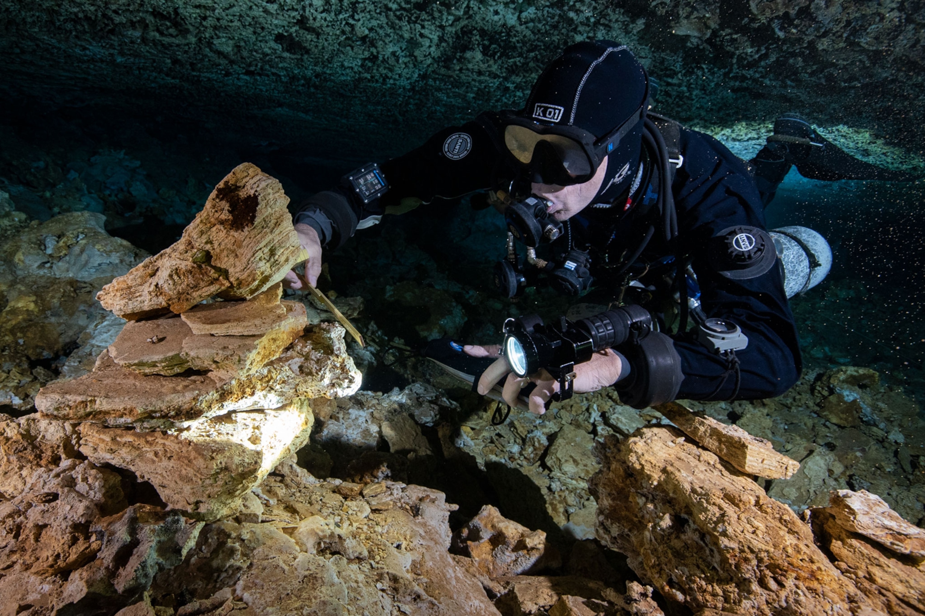 a diver examining a marker in an ancient cave in Mexico