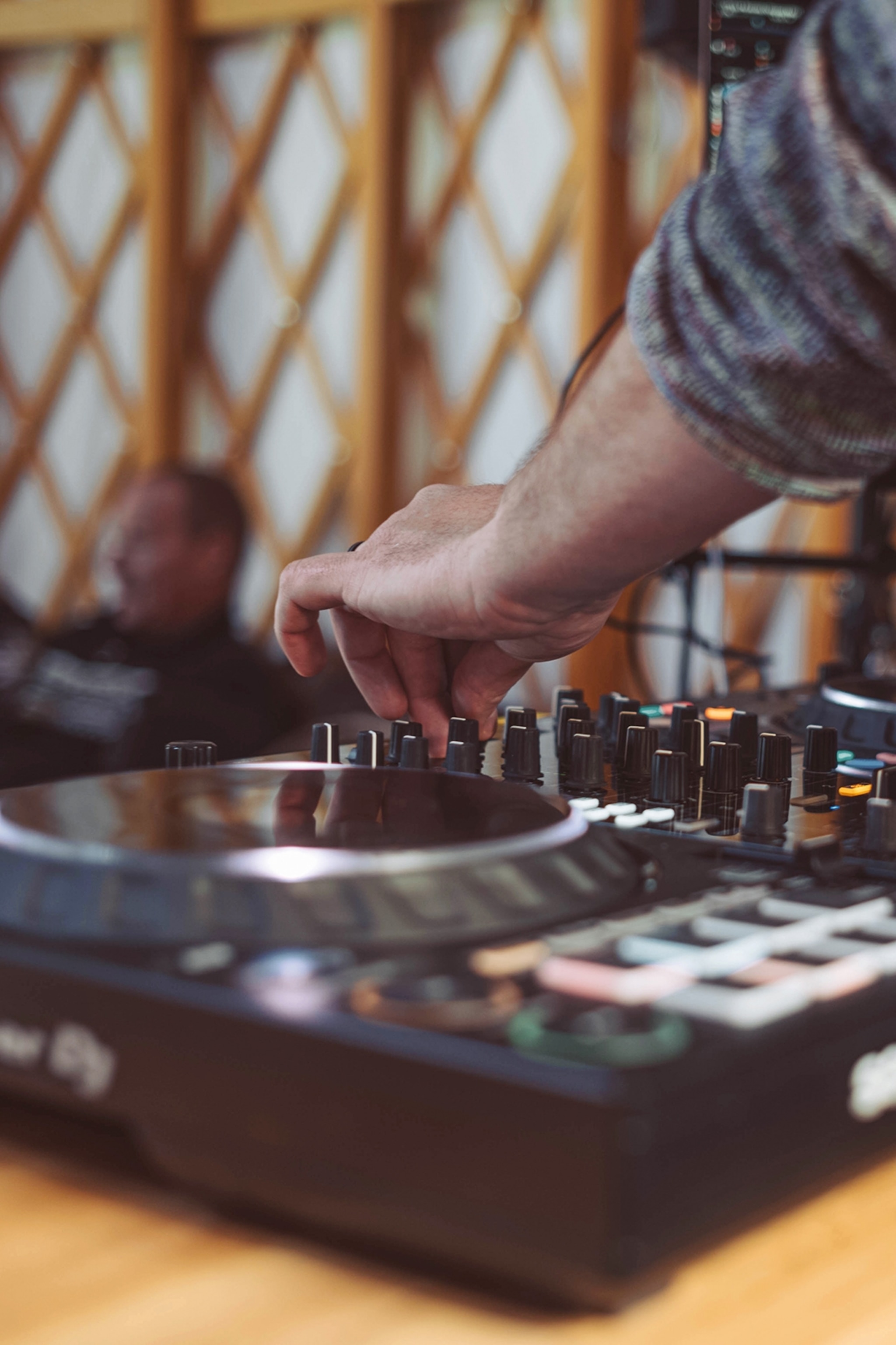 A man regulating music with a DJ desk.