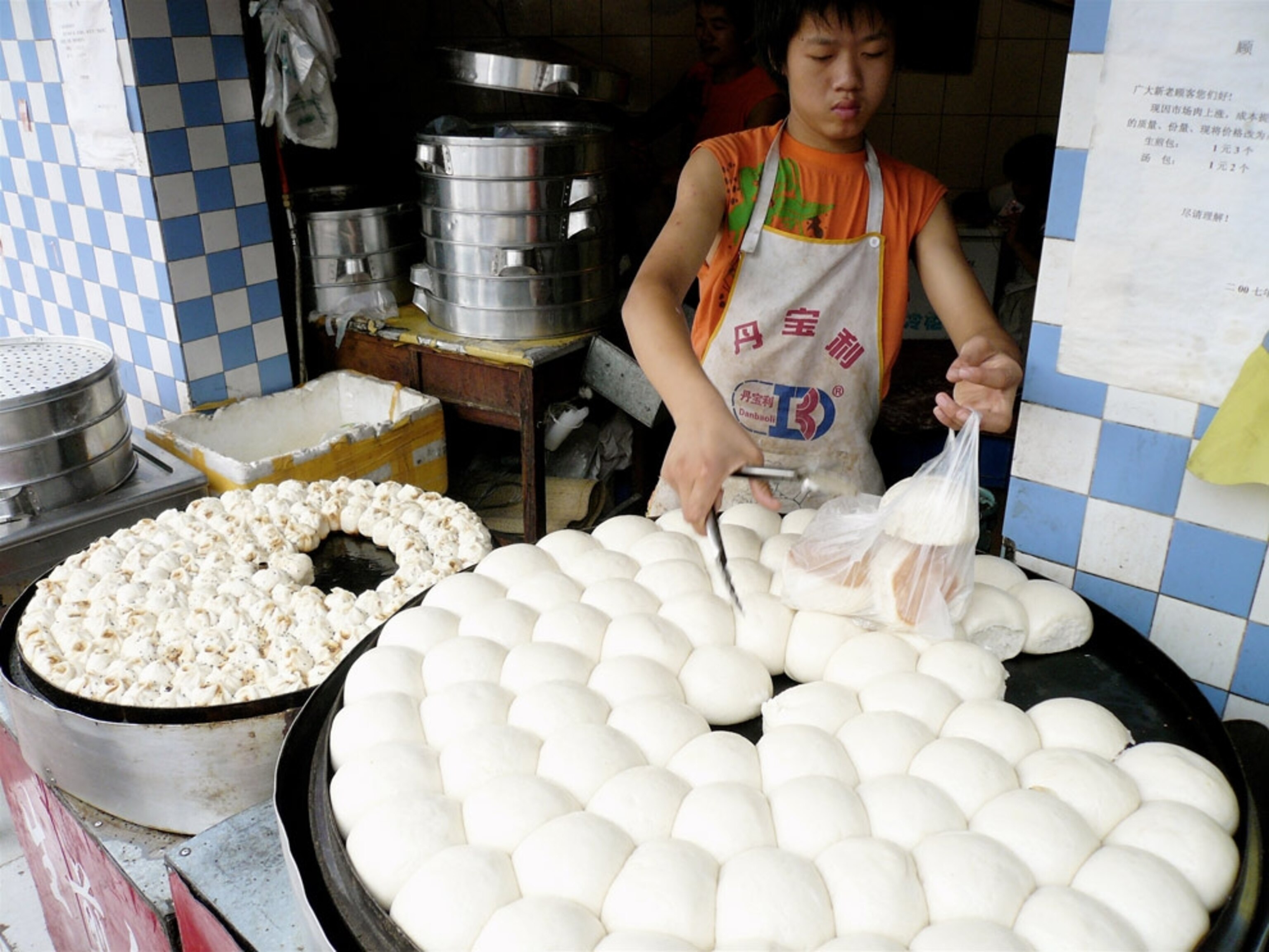 A baker bagging fresh rolls