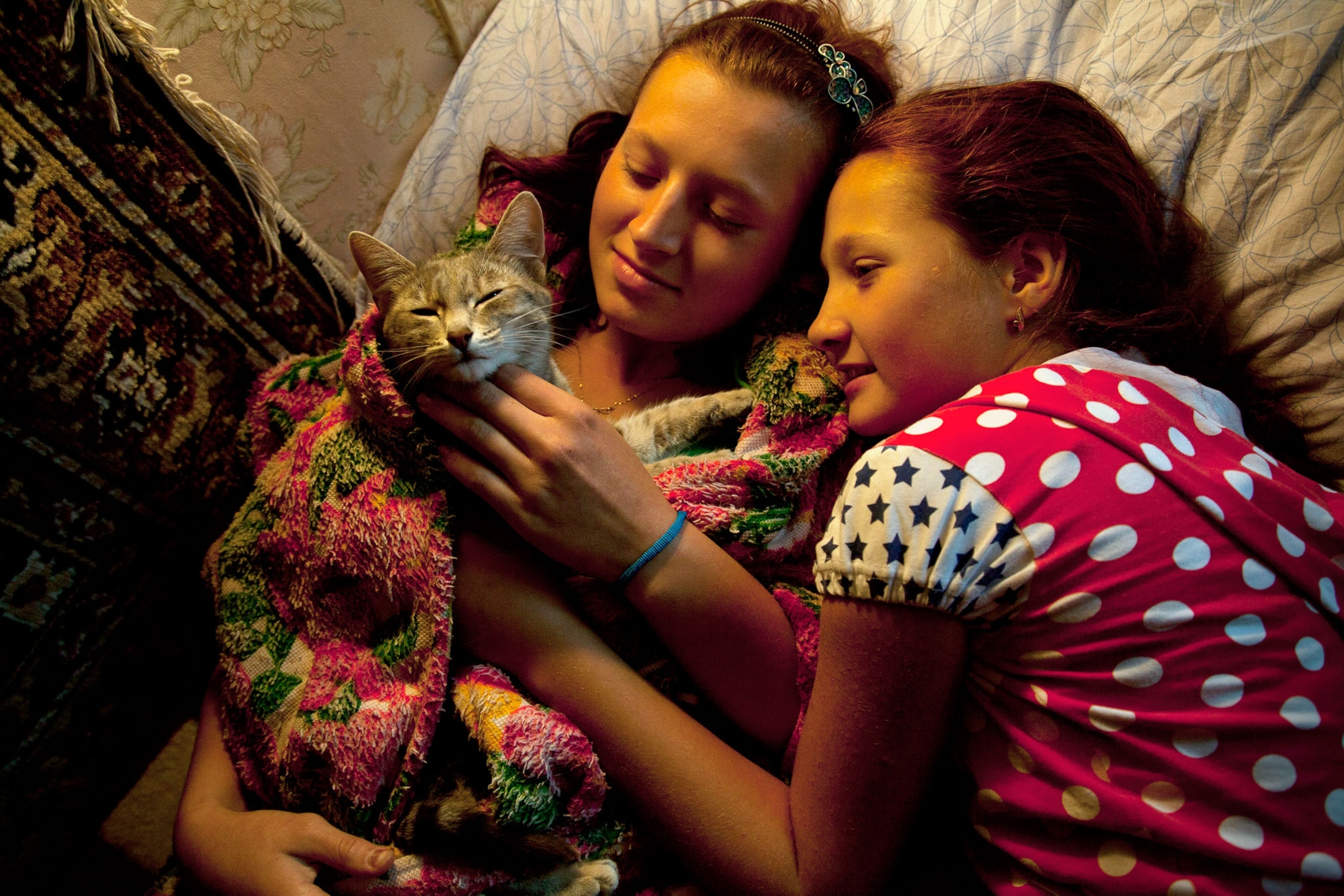 two girls playing with cat