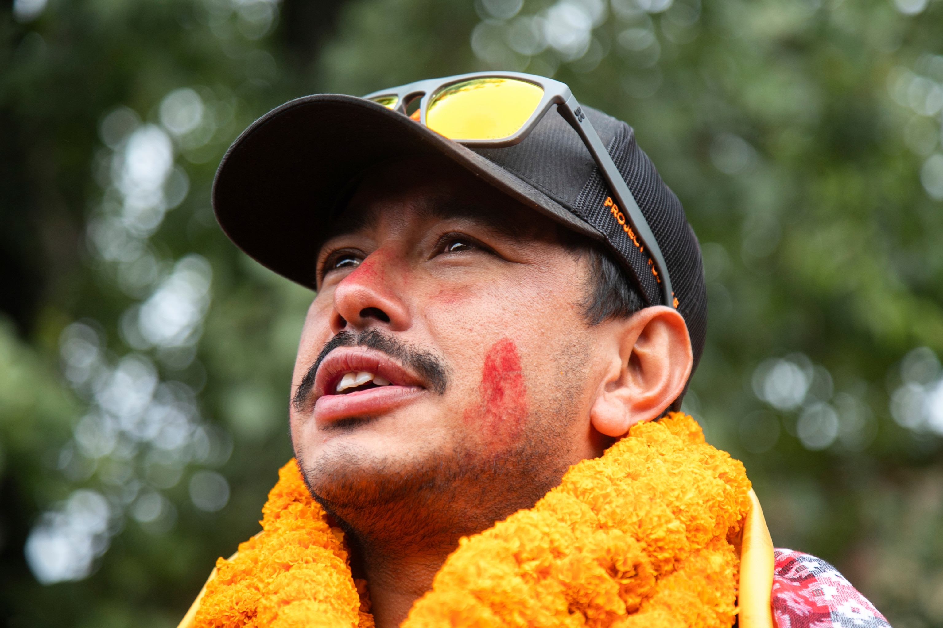 Nirmal Purja smiles as he looks off into the distance.