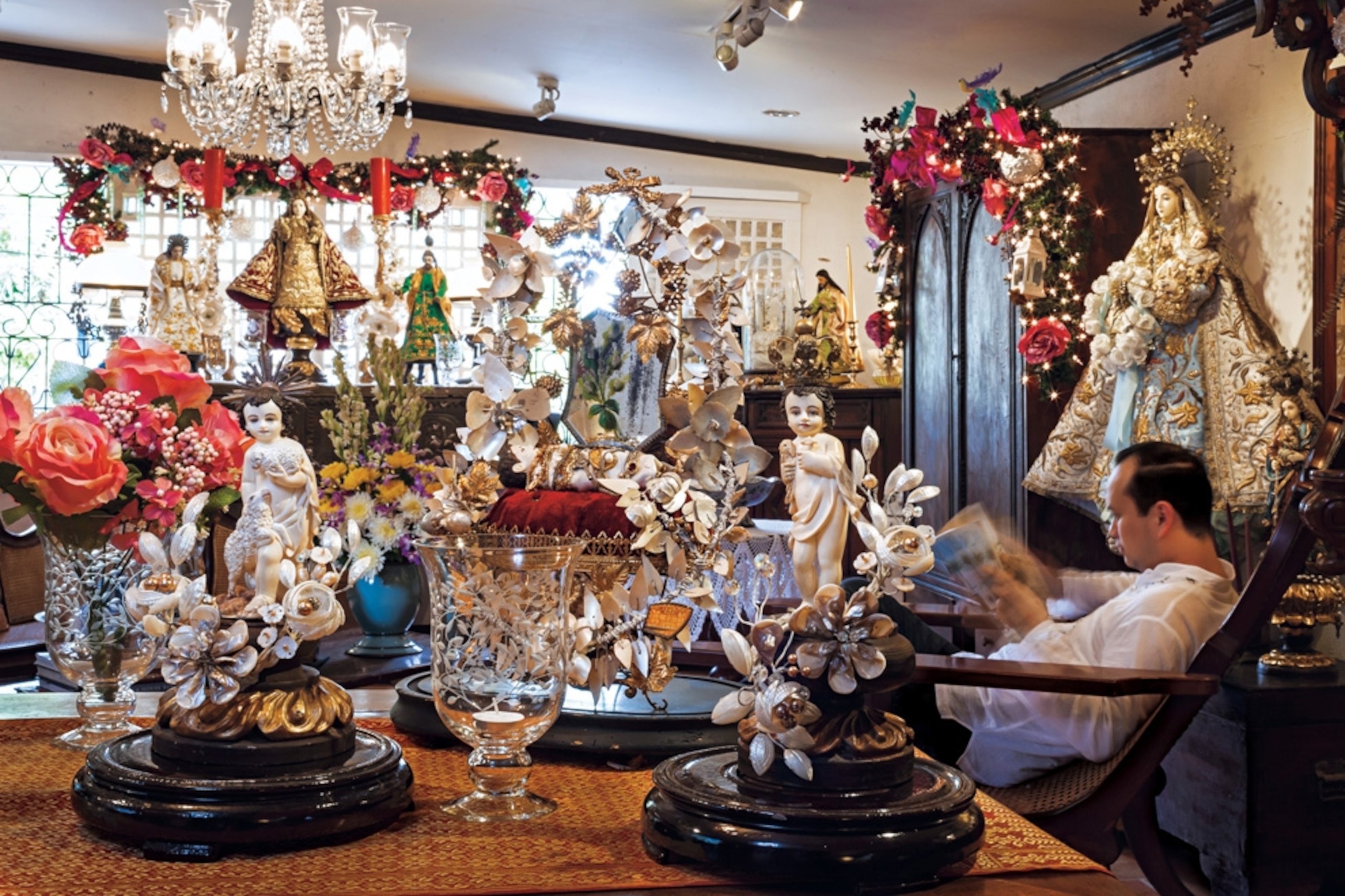 an ivory collector at home surrounded by many lavish, ivory religious icons