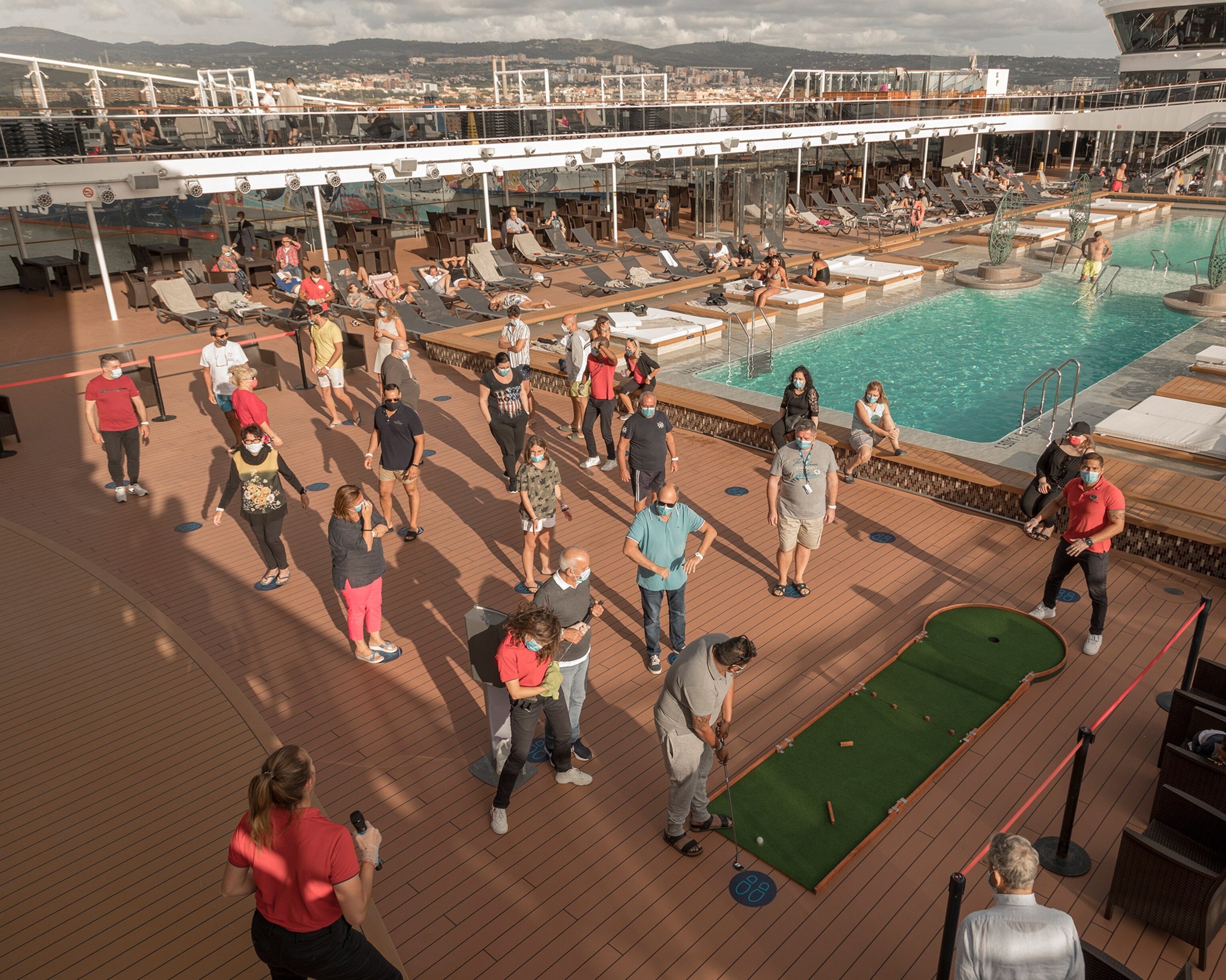 people waiting in line on the dock of the ship playing minigolf