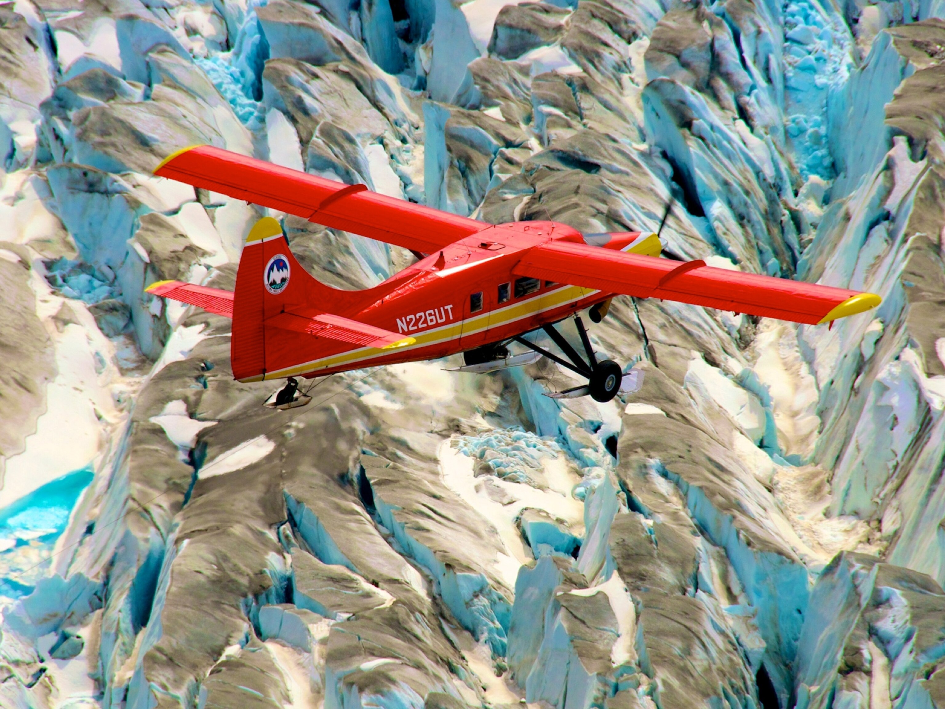 a red plane flying over the Arctic.