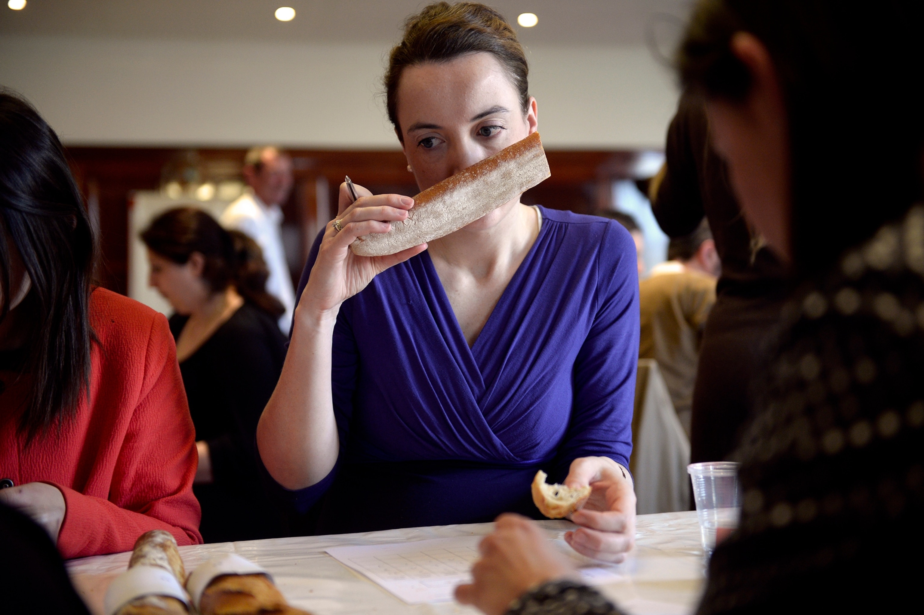 A member of the jury smells a French 'baguette' bread during its consideration as part of the 'Best baguette of Paris' contest, on March 13, 2014, in Paris.