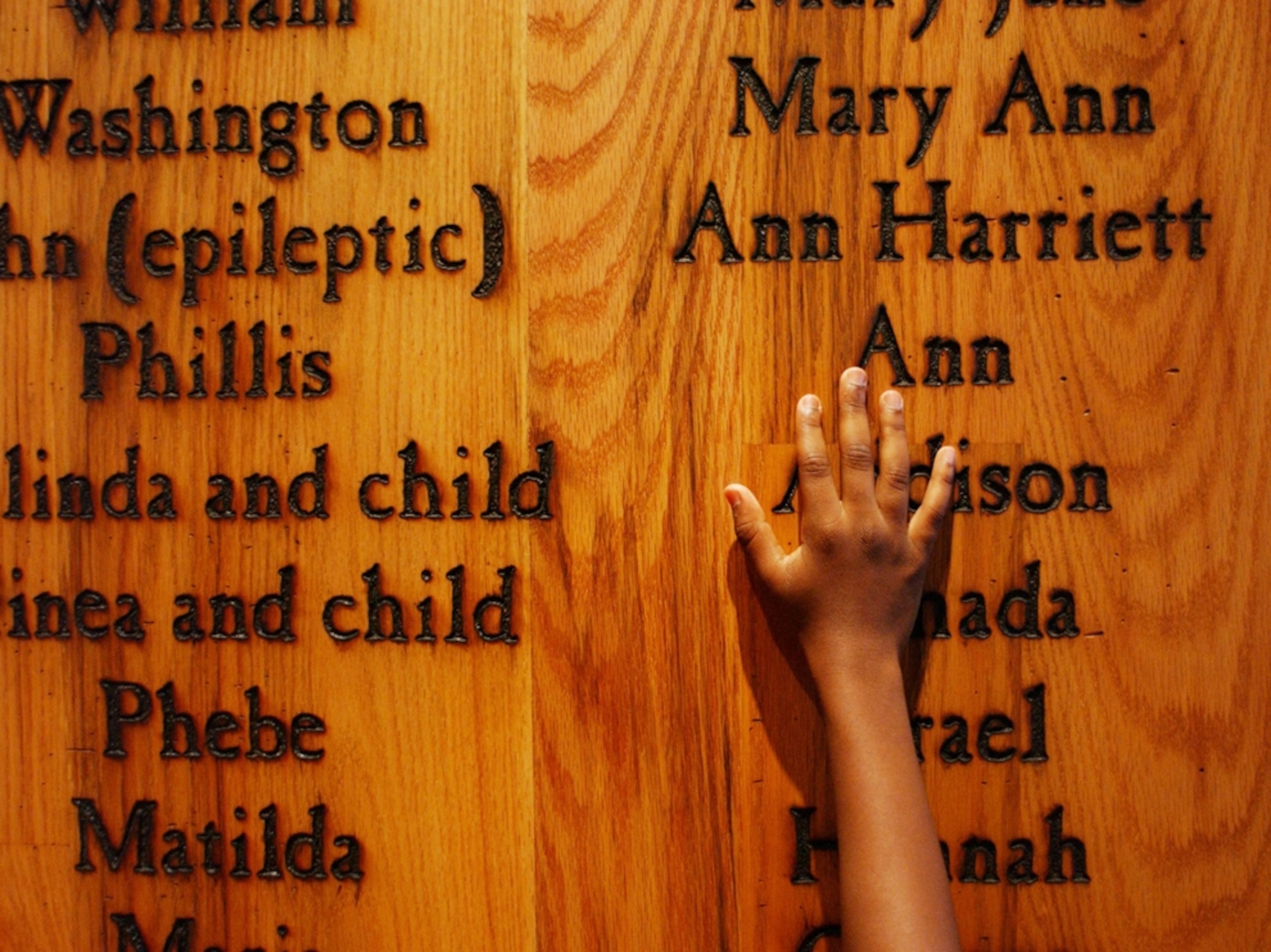 Child touching names of slaves
