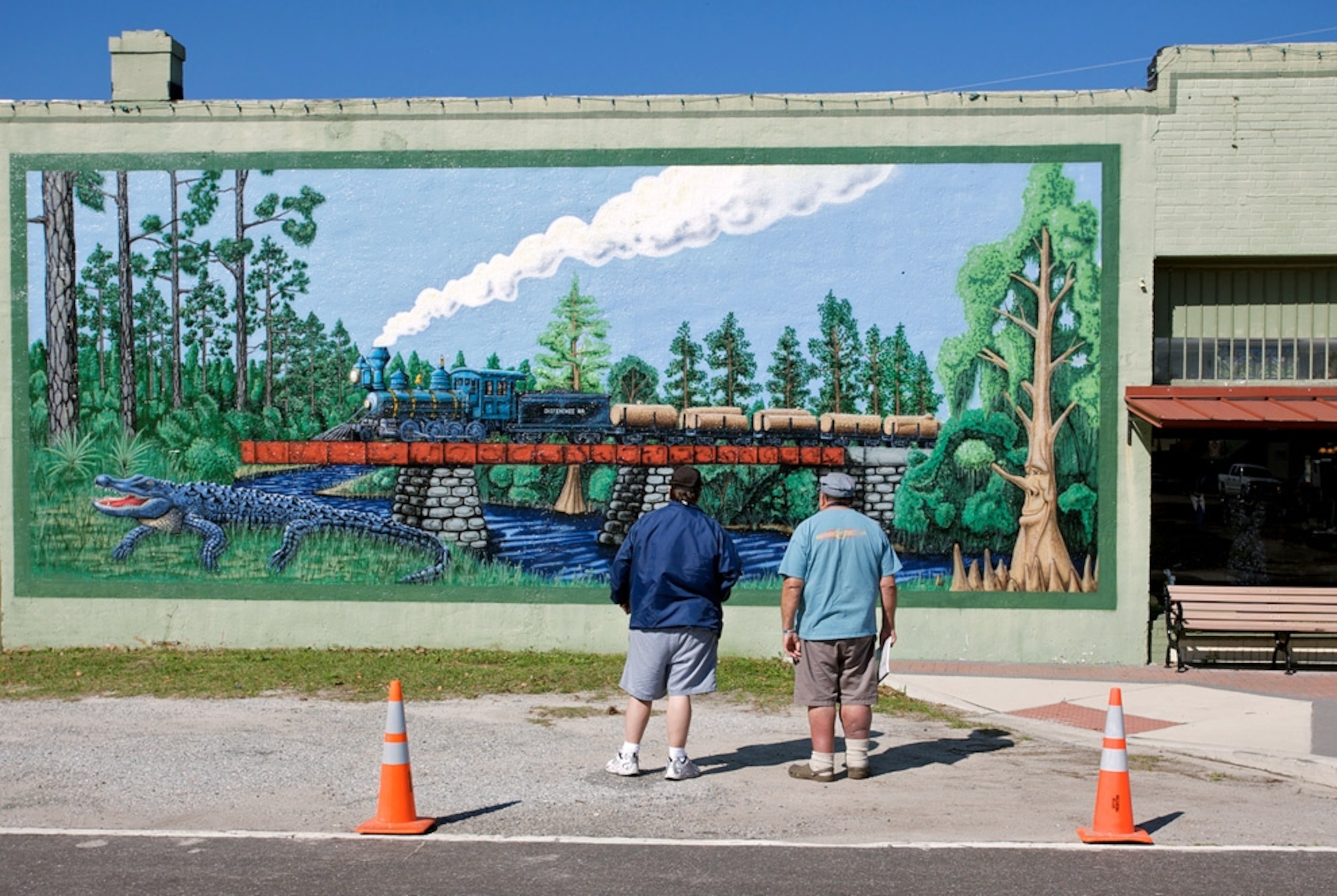 Two men looking at train mural