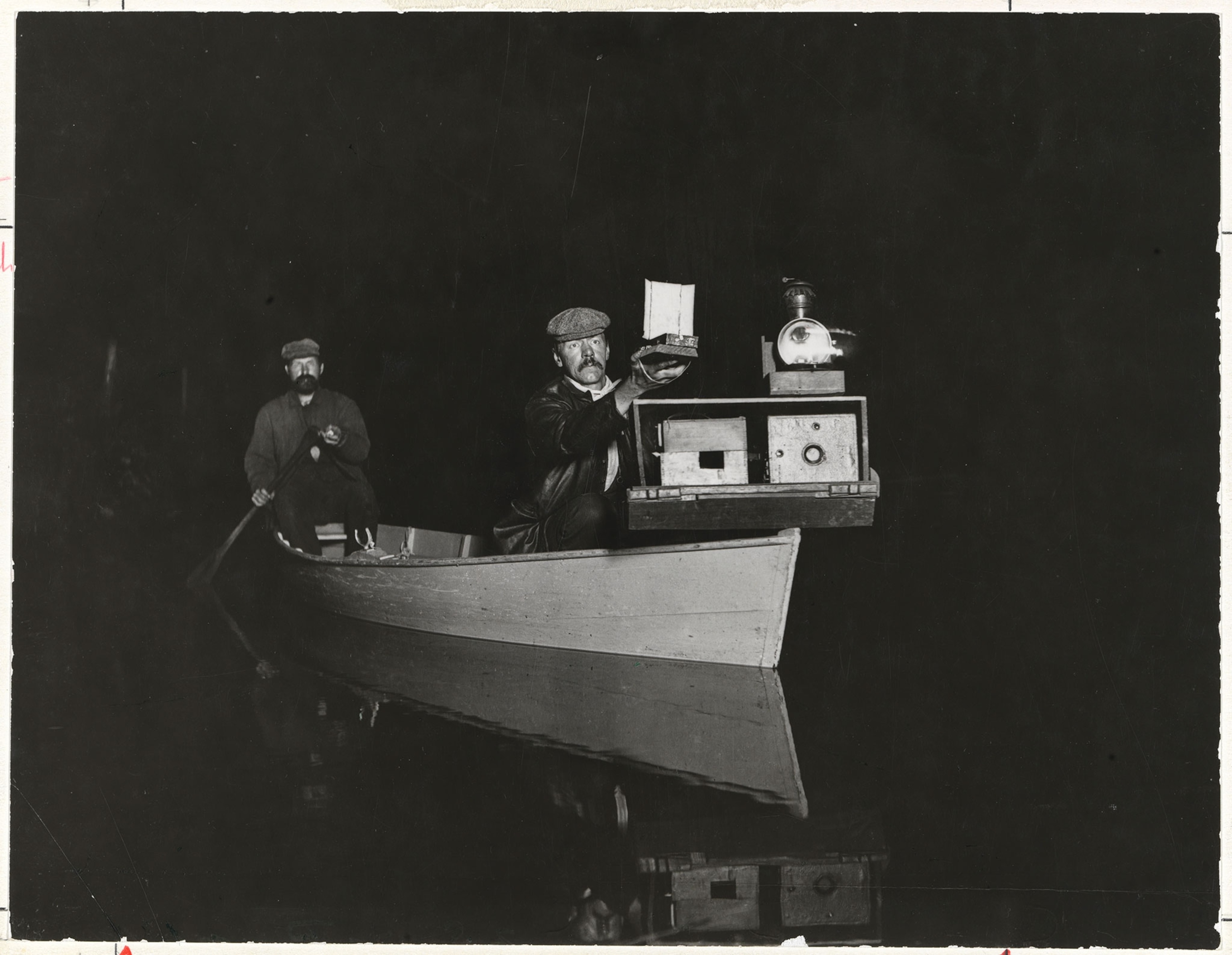 a man with a camera in a boat.