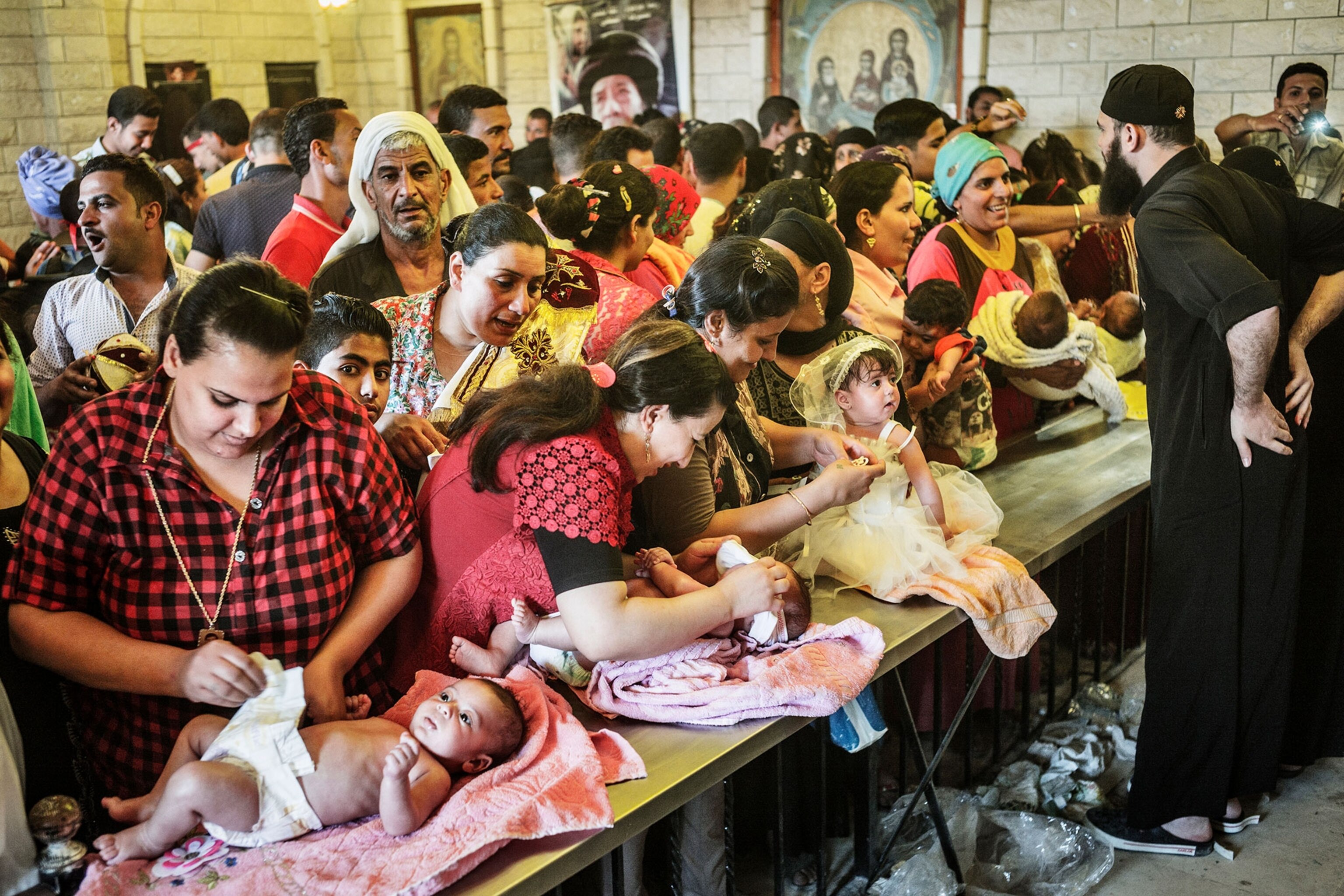 women line up their babies to be baptized at the Gebel al-Tier moulid
