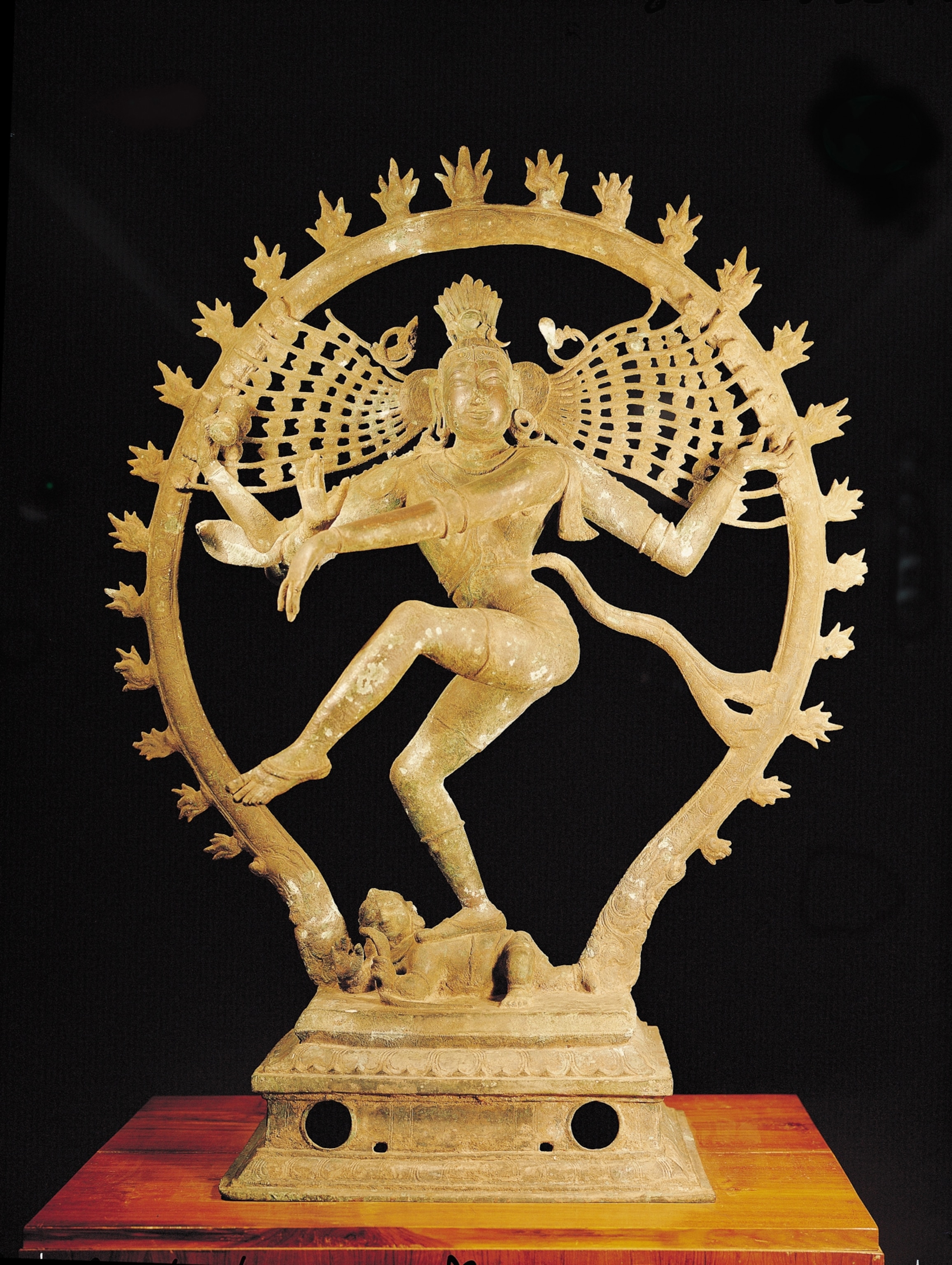 Bronze statue of a dancing figure, representing Shiva Nataraja, with an ornate halo, dynamic pose, balanced on one leg