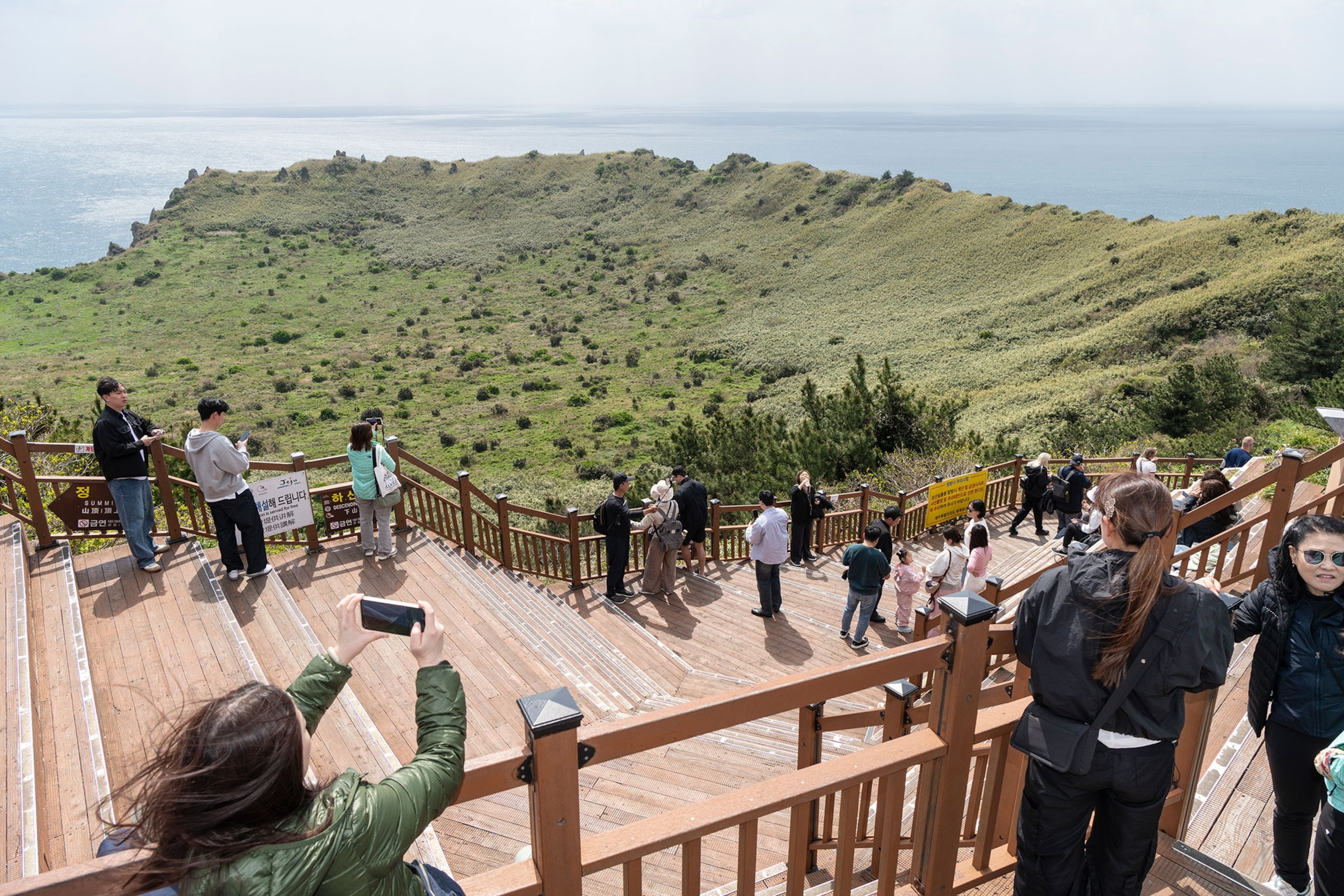 People take photographs from a viewing platform at Seongsan Ilchulbong, also called Sunrise Peak, a volcano on eastern Jeju Island. It is 182 metres high and has a volcanic crater at the top.