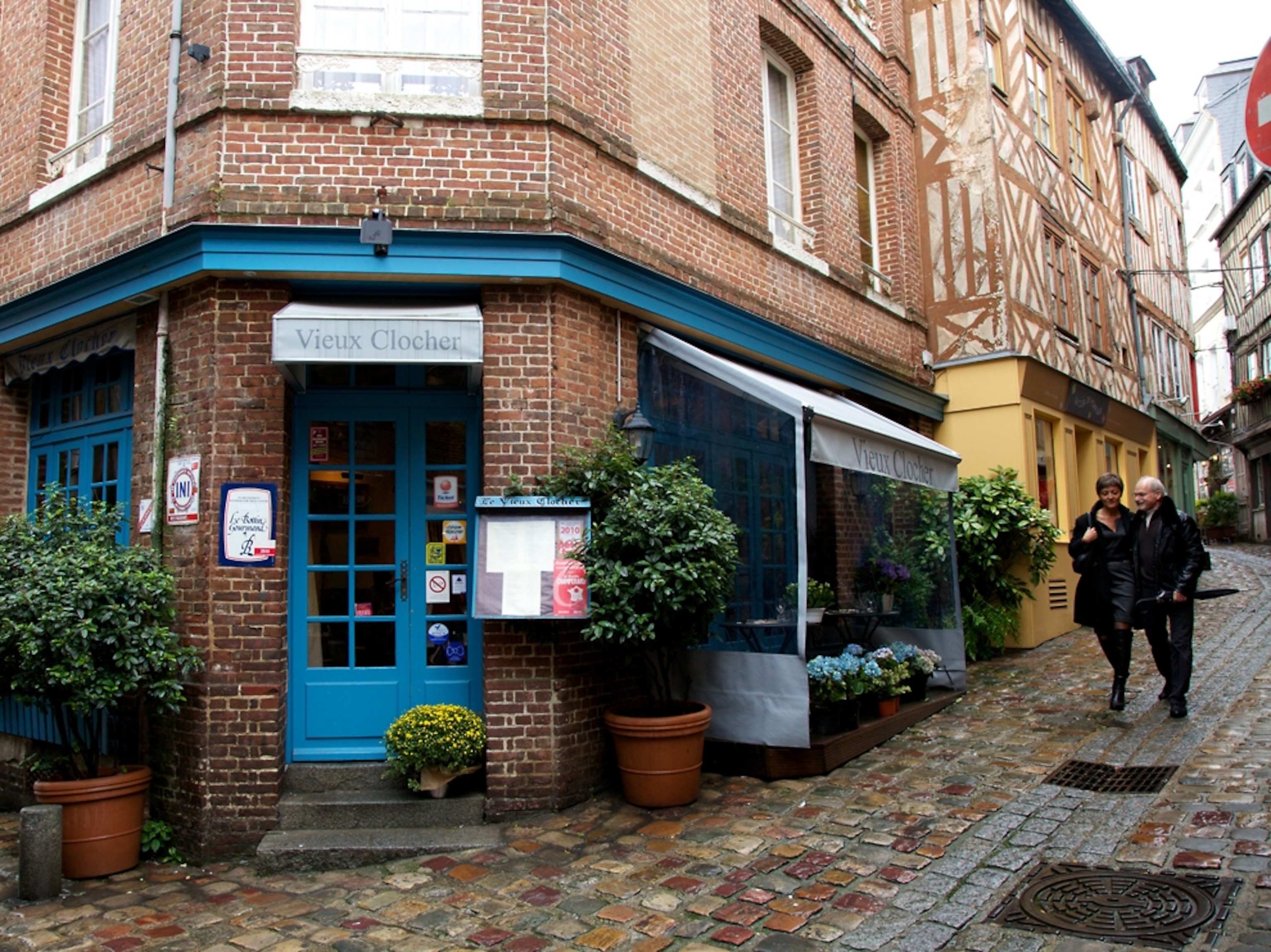 Couple walking down street by restaurant in Normandy