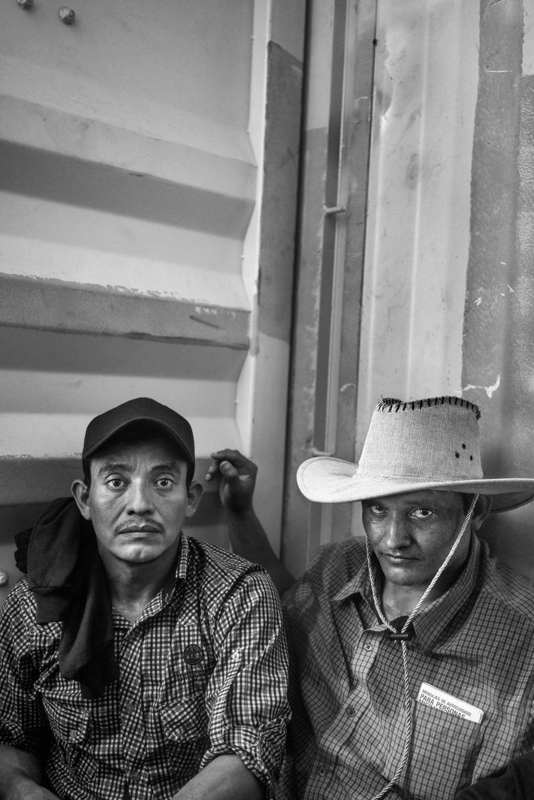 two men, one in a white hat, inside a container