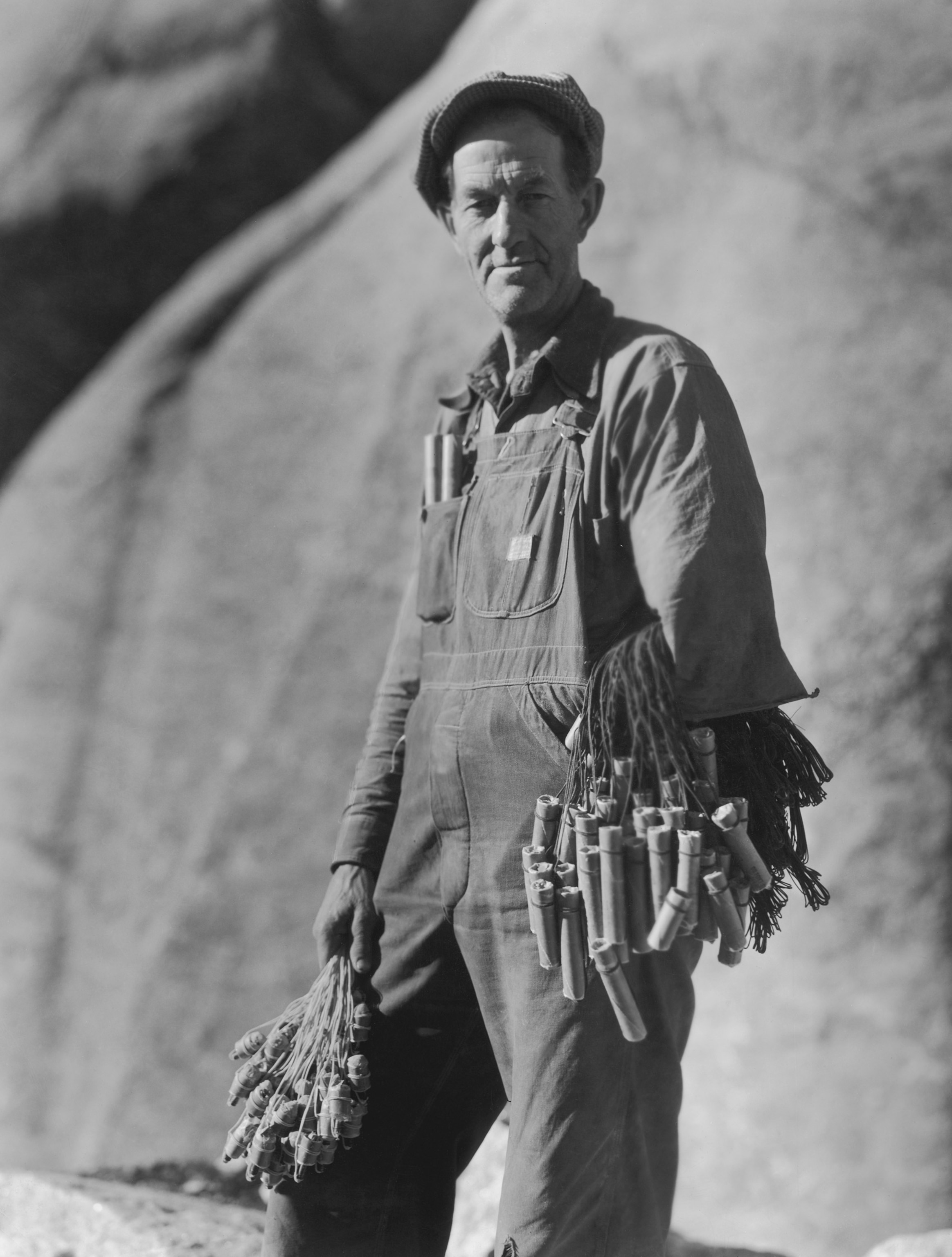 a person working on Mount Rushmore holding dynamite and detonators