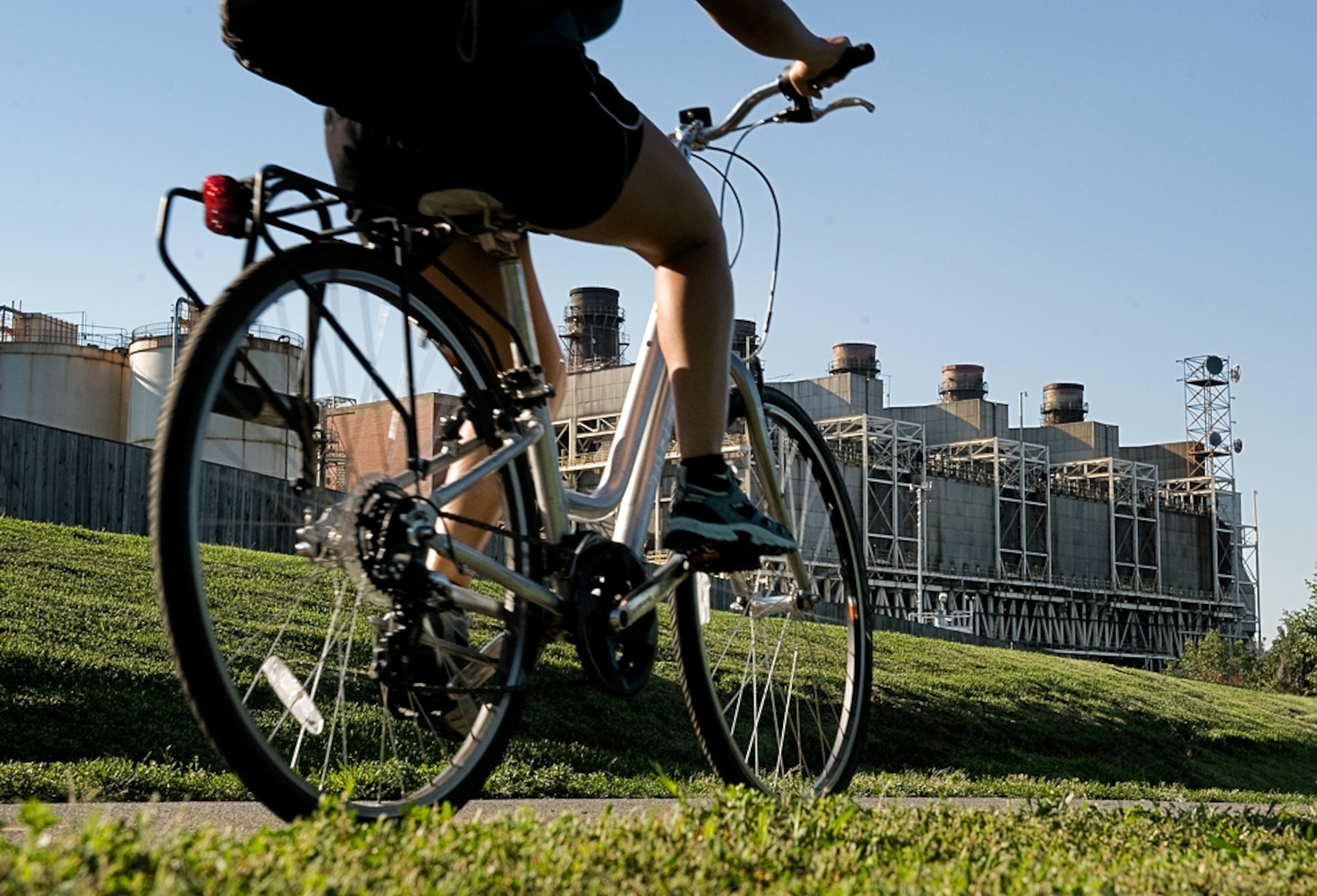 A cyclist passes a coal plant on Mount Vernon trail in Alexandria, Virginia