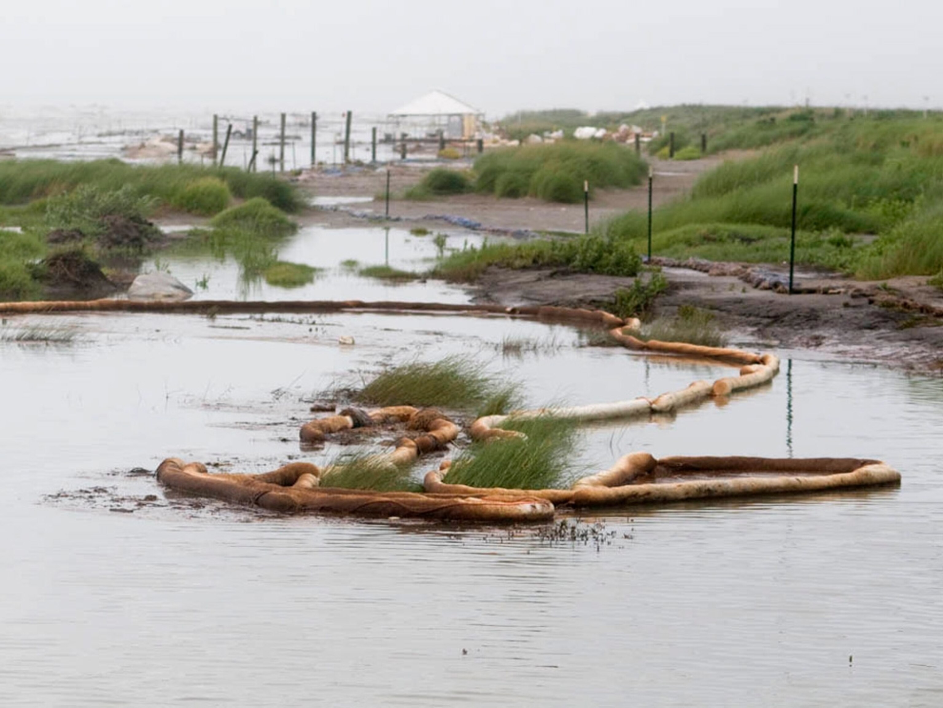 oil-stained booms floating along the coast of Port Fourchon, Louisiana.