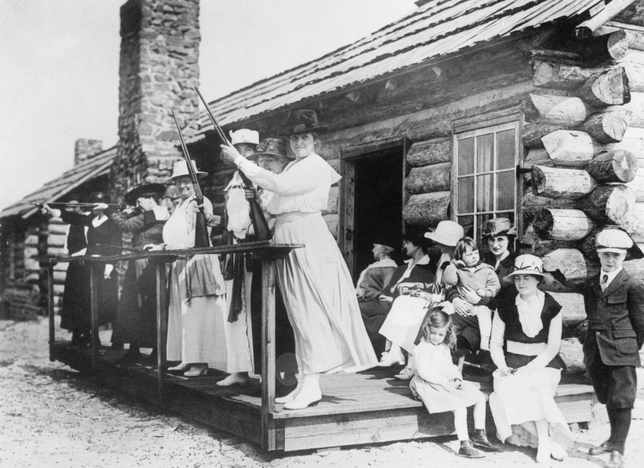 black and white photo of Annie Oakley teaching women how to shoot guns