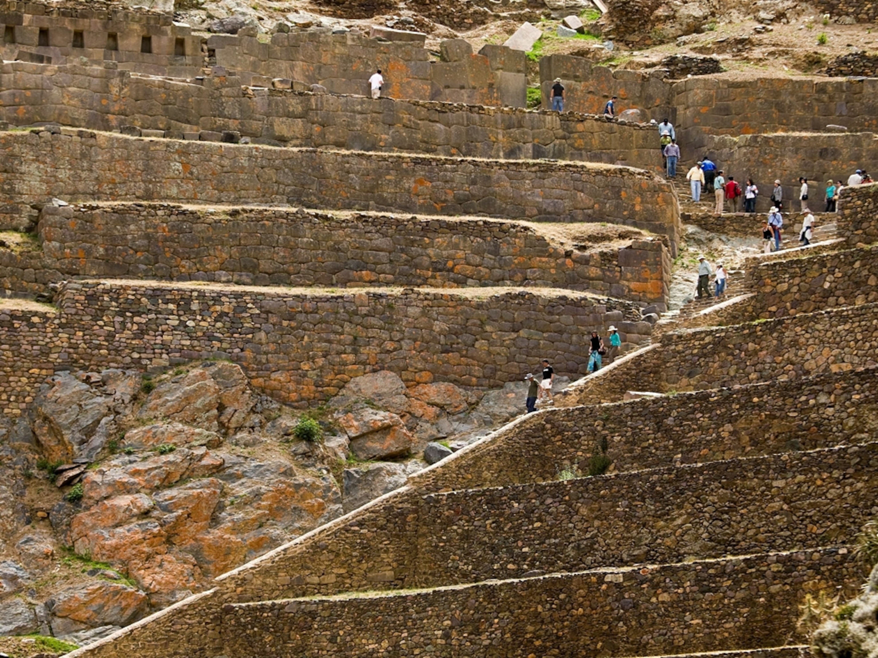 Tourists descending stairs at Ollantaytambo Inca ruins in Peru