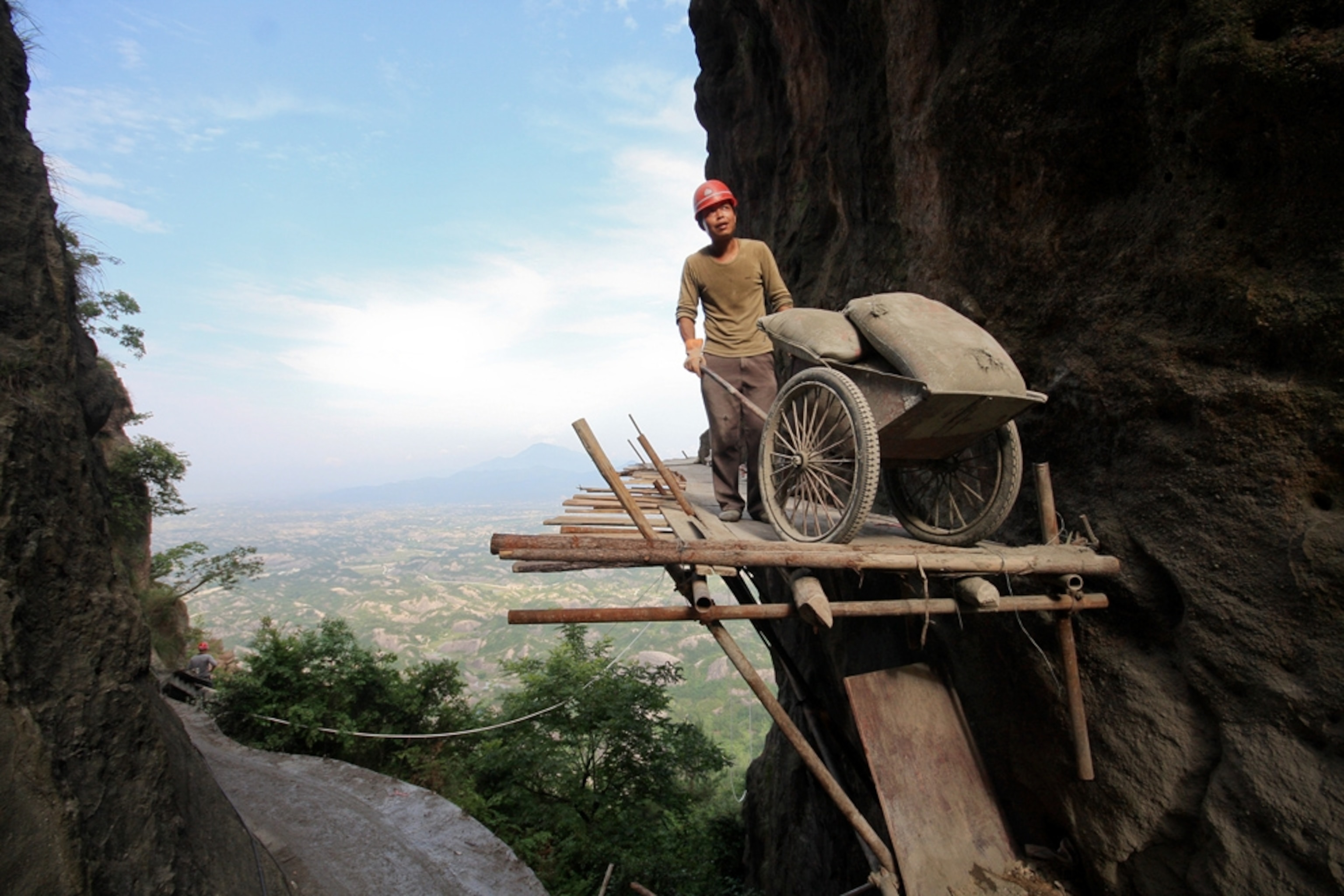 a worker transporting materials to build a road in China