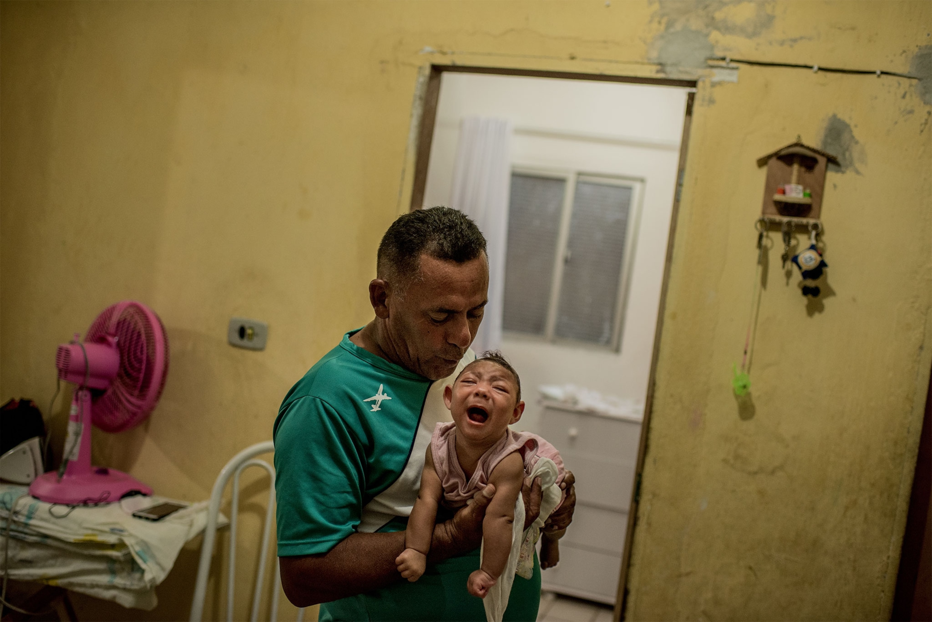In Recife, Brazil, Zika virus has been linked to birth defects in babies born to infected mothers. Here, Joao Batista comforts his daughter Alice Vitoria, who has microcephaly.