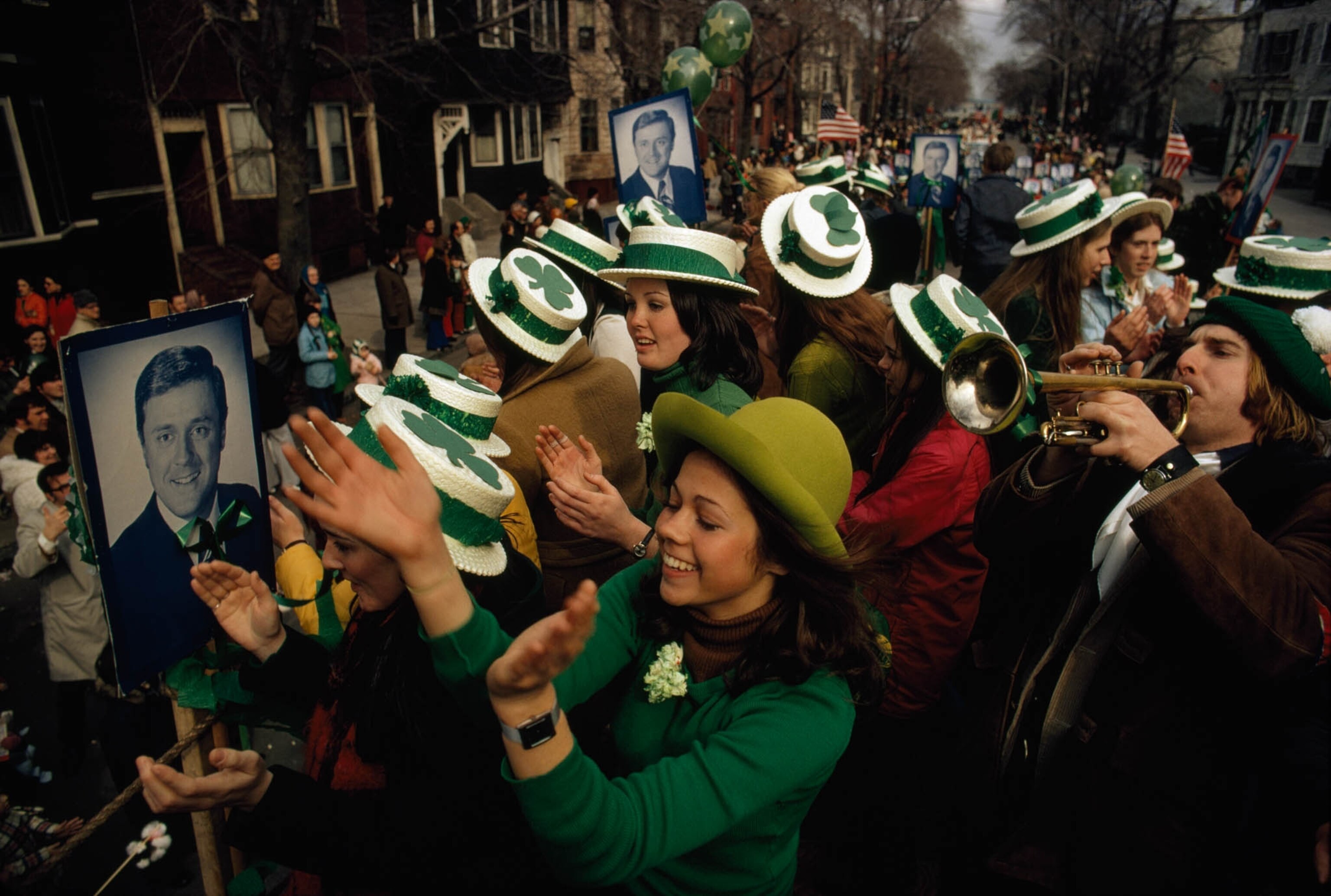Participants in a St. Patrick's Day parade wearing hats with shamrocks on them
