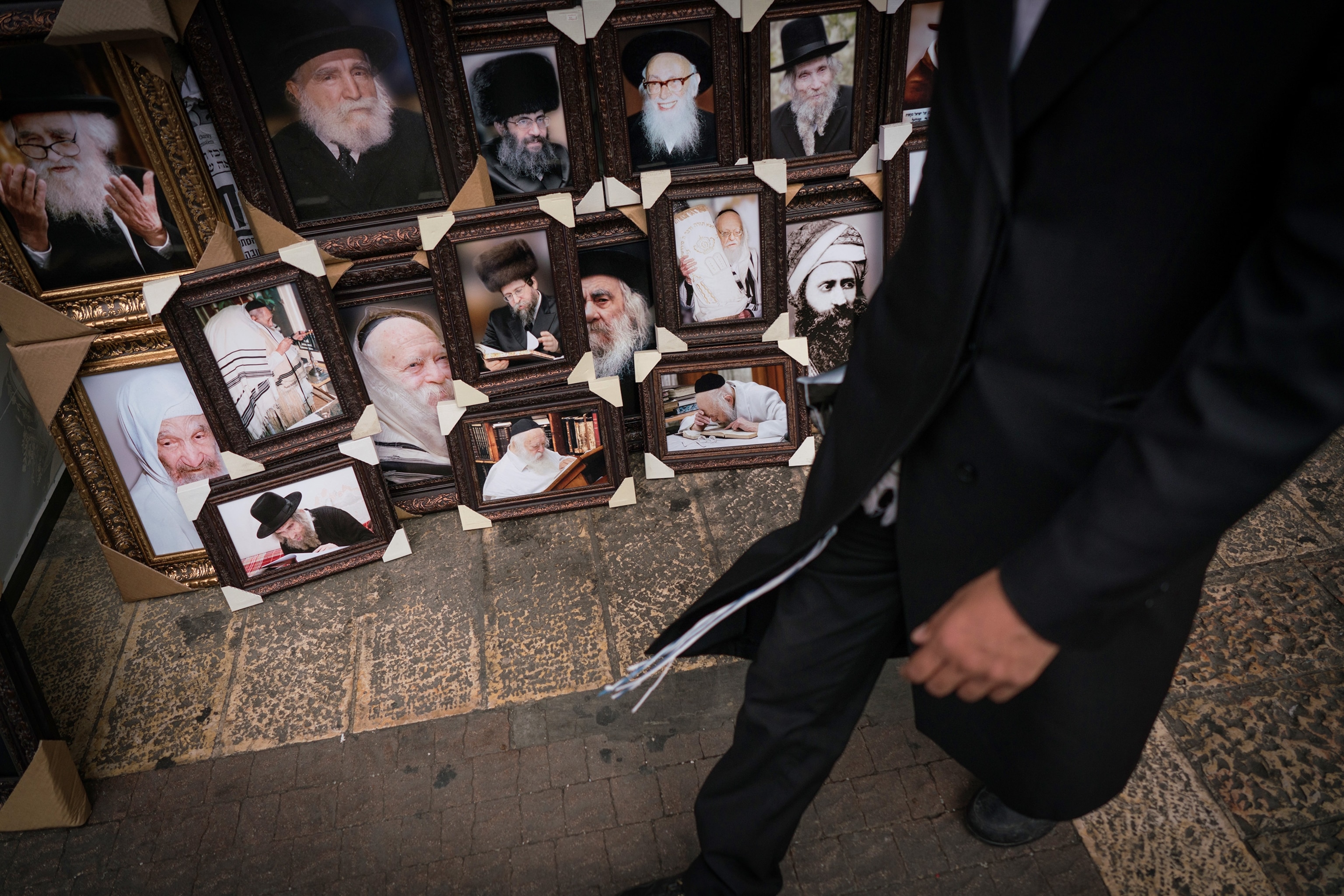 an Ultra Orthodox Jewish man walking next to a shop in Jerusalem, Israel